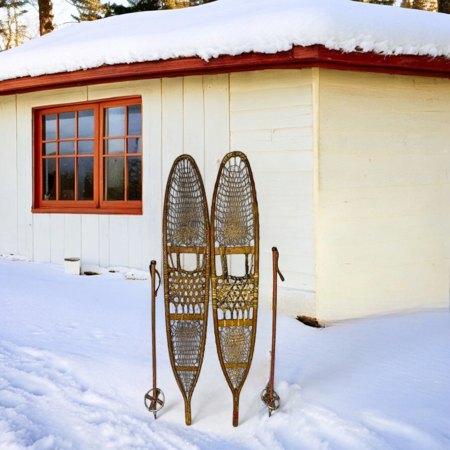 Vintage wooden snow shoes by C.A. Lund with wooden poles in front of a snow covered cabin in the woods.