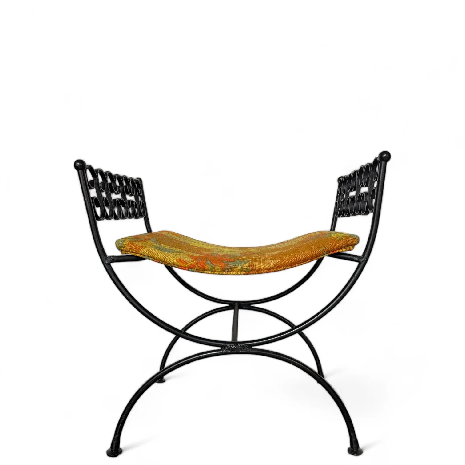 Vintage vanity stool chair made of black wrought iron with a curved 70s retro floral seat consisting of yellows, oranges, greens from Modern Artifact Decor.