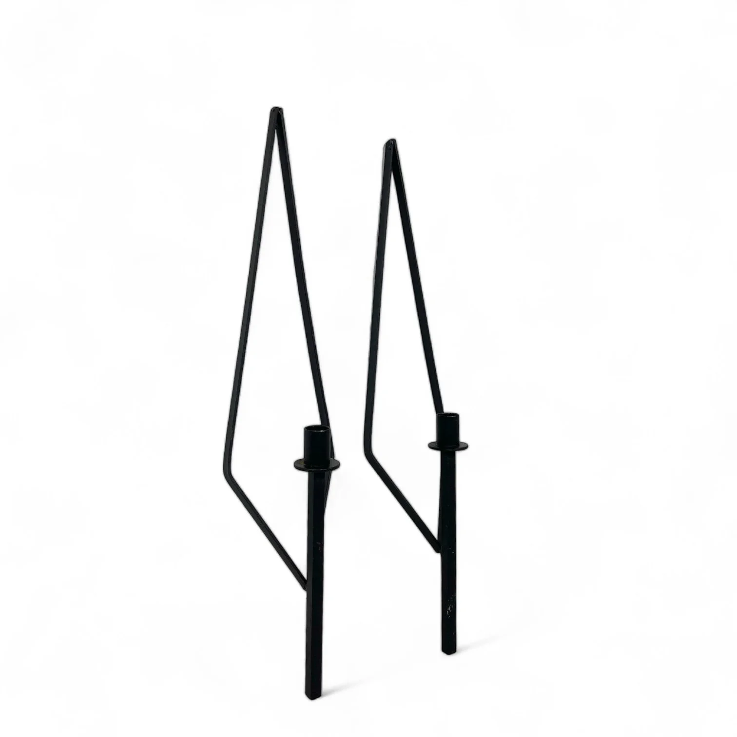 Pair of black metal wall mount candle holders in the shape of an elongated diamond, that holds a taper candle