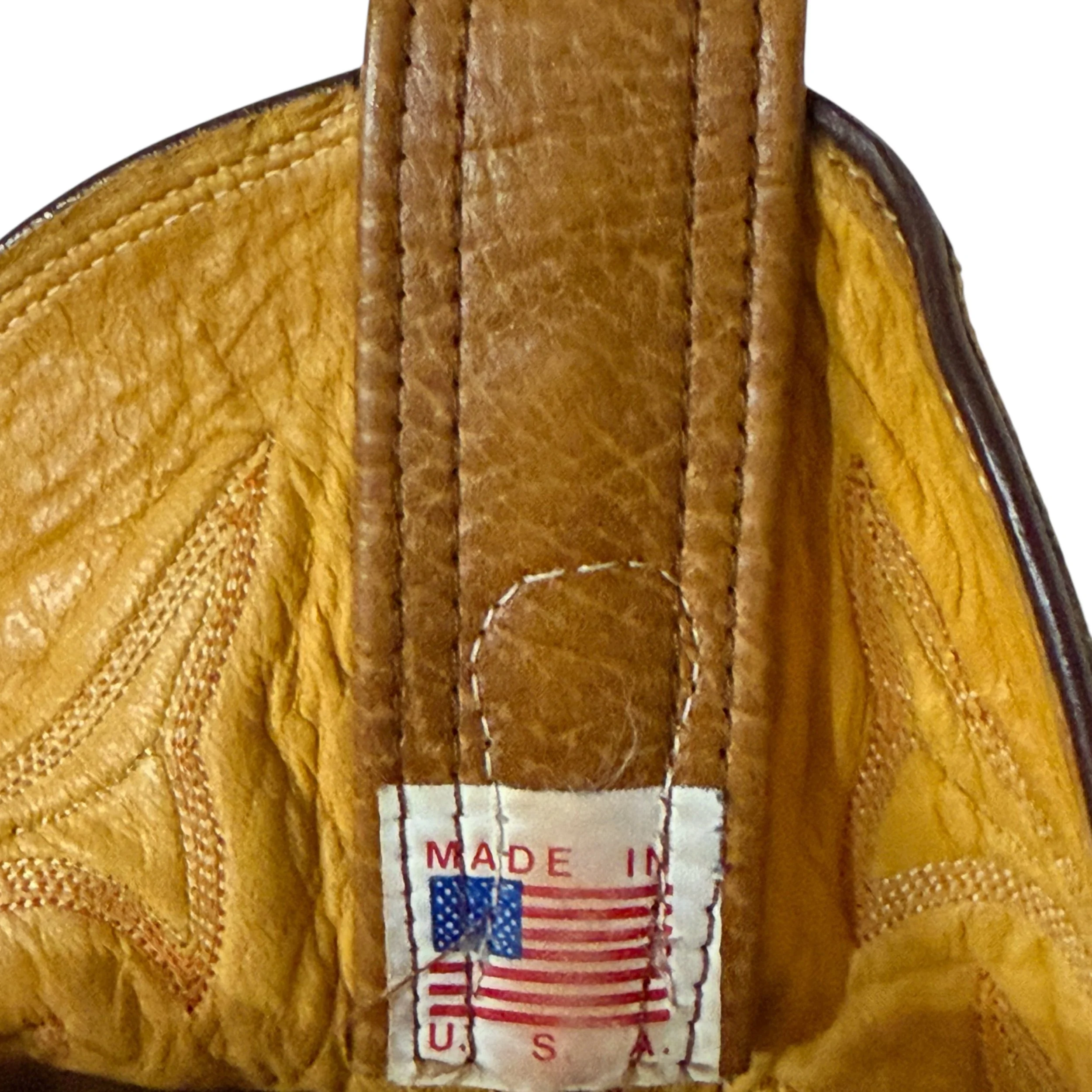 Close up view of a Made in the USA label with an American flag on the inside of a vintage Olathe cowboy boot.