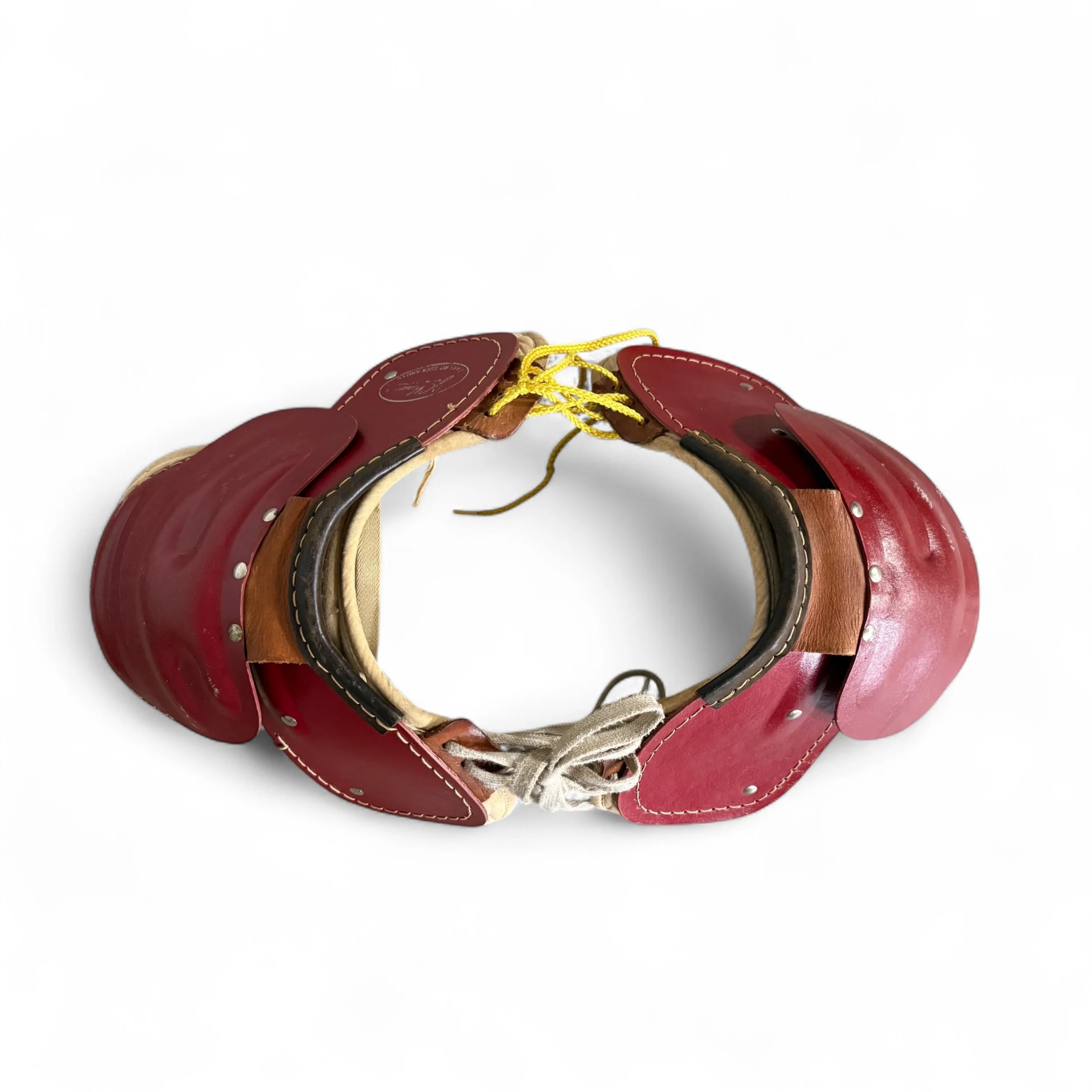 Top view of dark red vintage youth football shoulder pads with yellow and white laces