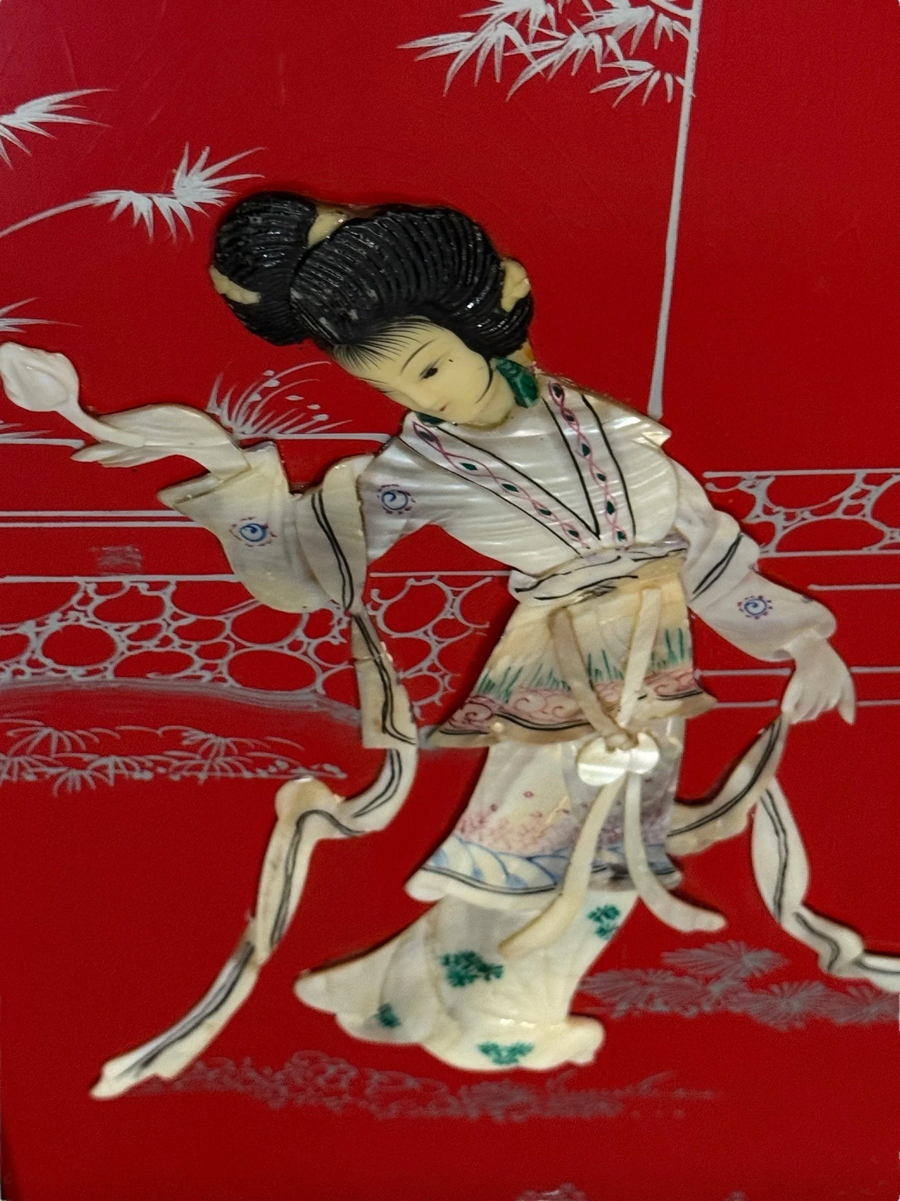 Close-up of mother of pearl geisha girls on lacquer vintage wood panels