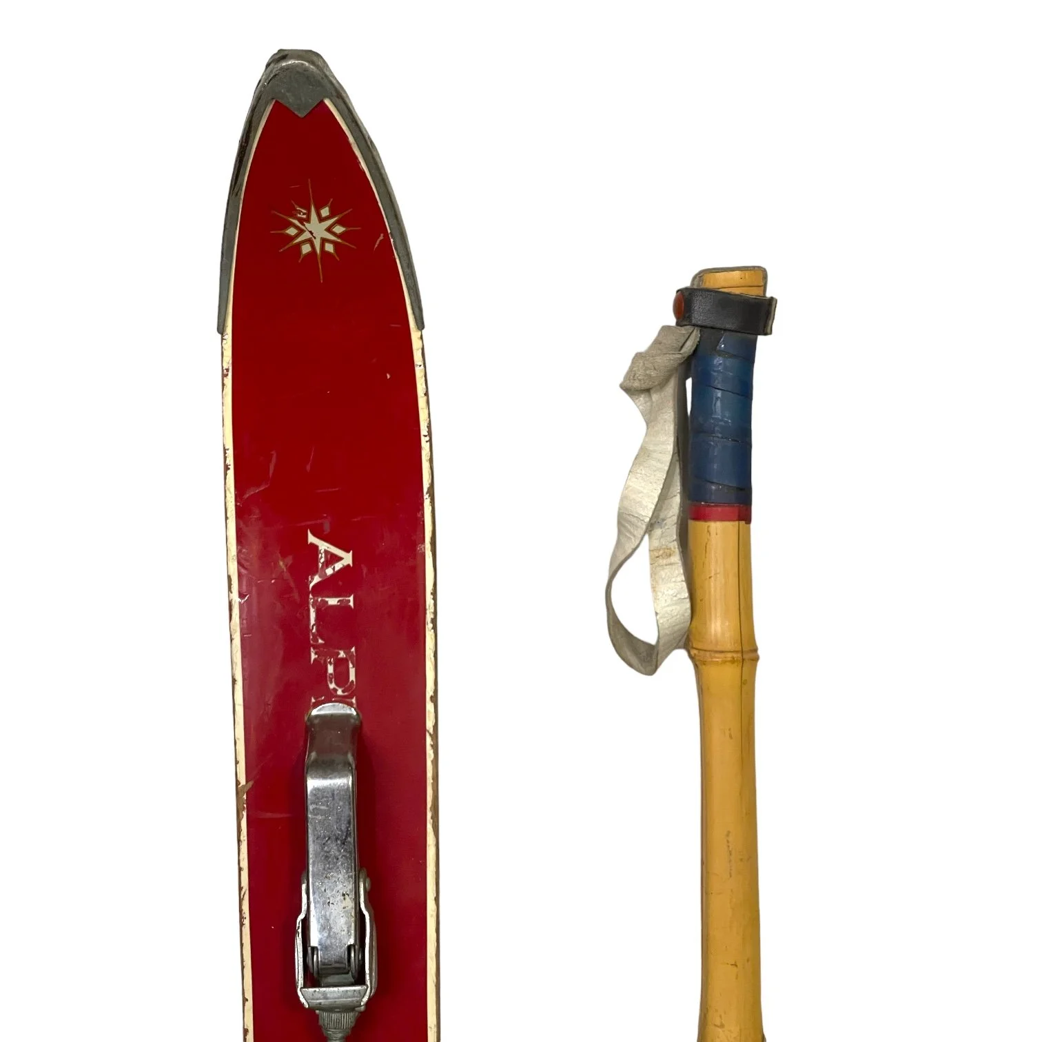 Pair of vintage red kids snow skis with metal bindings and bamboo ski poles, perfect for winter cabin or lodge decor.
