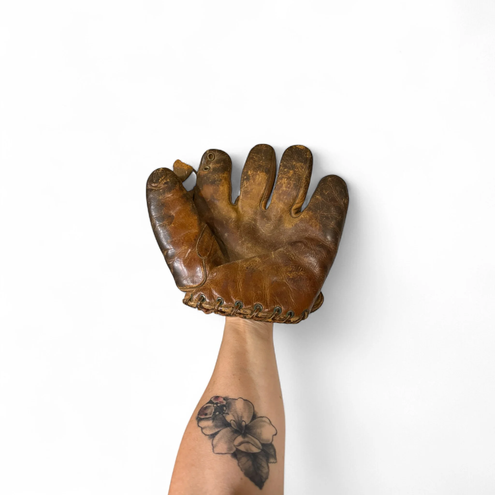 Vintage 1930s Rawlings leather baseball glove with rich patina, ideal for sports collectors and rustic game room decor.