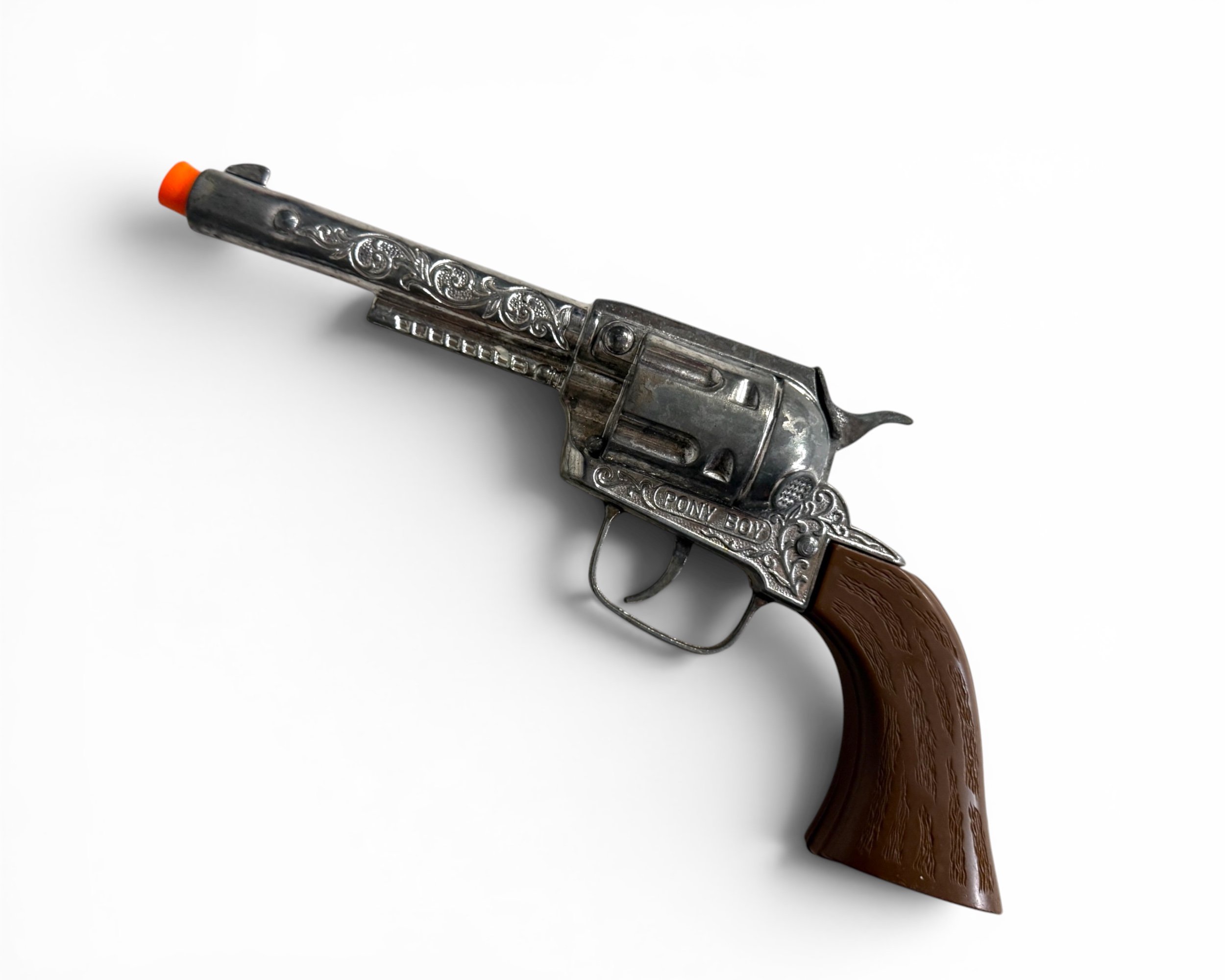 Vintage Pony Boy cap gun with engraved Western styling and wood-tone grip.
