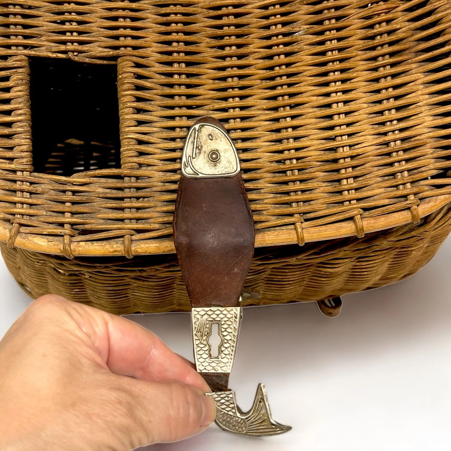 Vintage wicker fishing creel with adjustable leather shoulder strap and leather and metal lid clasp shaped as a fish. Great rustic decor for cabin or lodge.