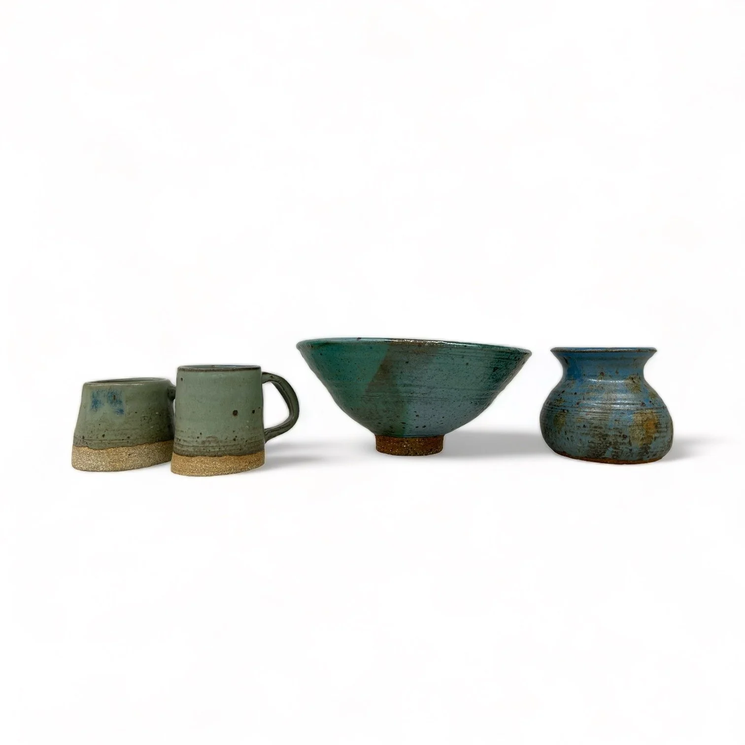 Vintage four piece set of 70s turquoise studio pottery that includes two mugs, bowl, and vase.