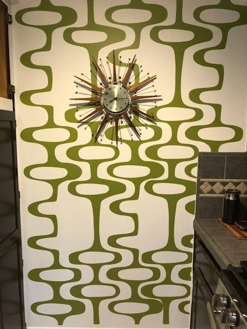 Mid Century geometric pattern wall decal by Wall Star Graphics shown in olive on a white wall  in a kitchen.