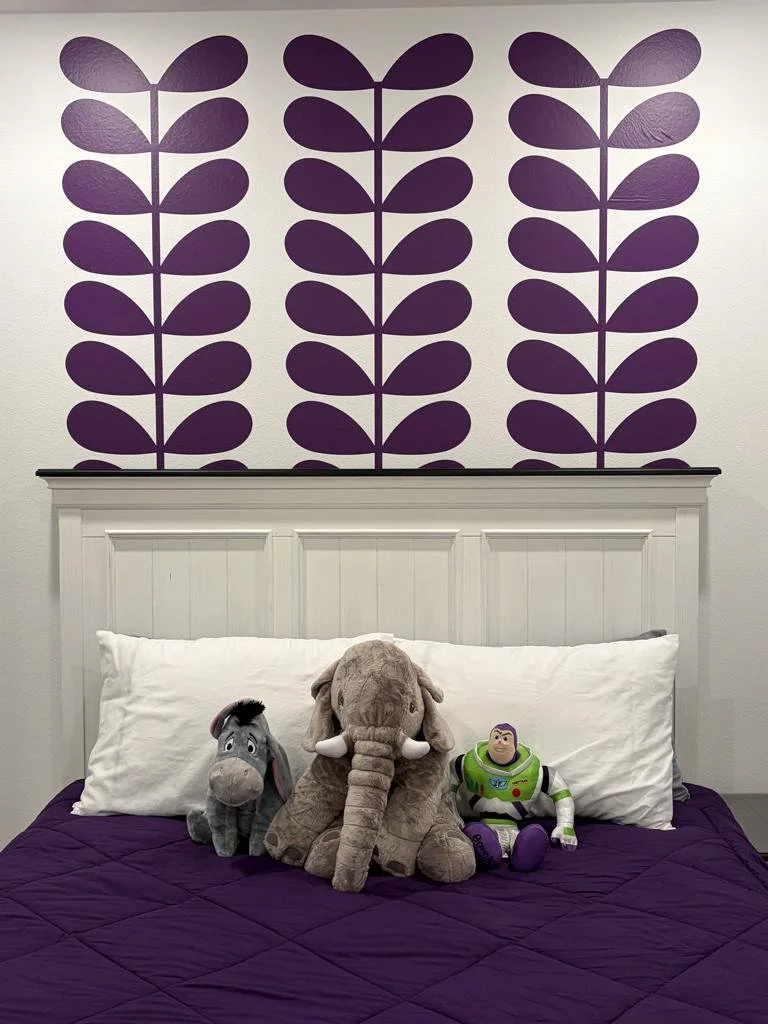Retro floral botanical leaf wall decal in purple installed above a headboard