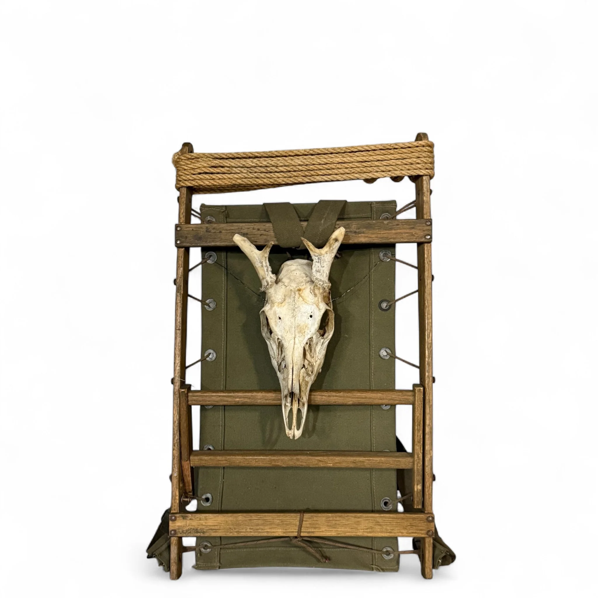 Vintage wooden packboard with mounted deer skull and army green canvas.