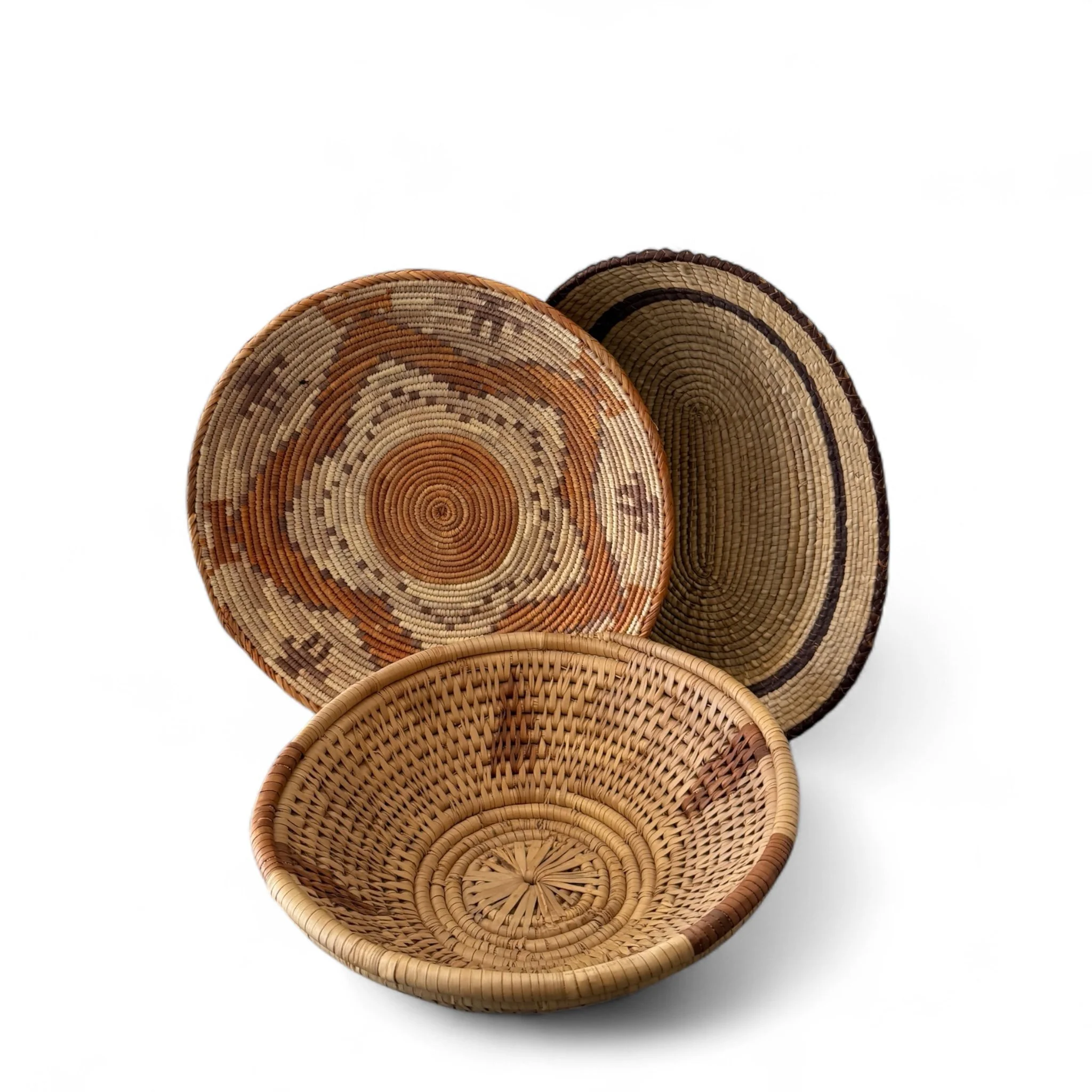 Set of three vintage woven coiled baskets with Southwestern tribal designs, displayed as wall decor in natural tones and rustic boho style.