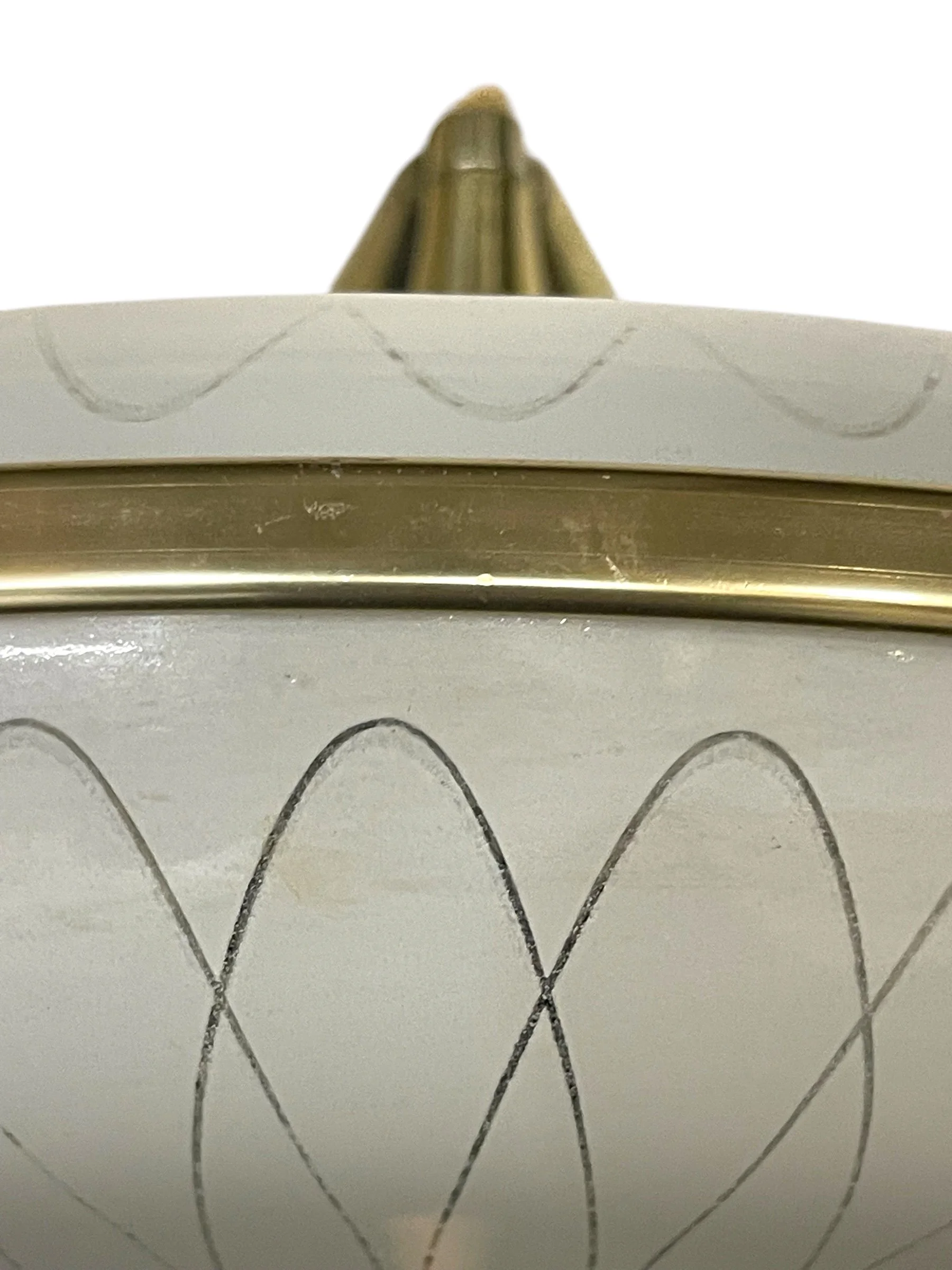 Close up of a vintage glass atomic saucer hanging ceiling light with 3 light sockets, showcasing its mid century modern design and sleek glass shade, perfect for retro and modernism decor.