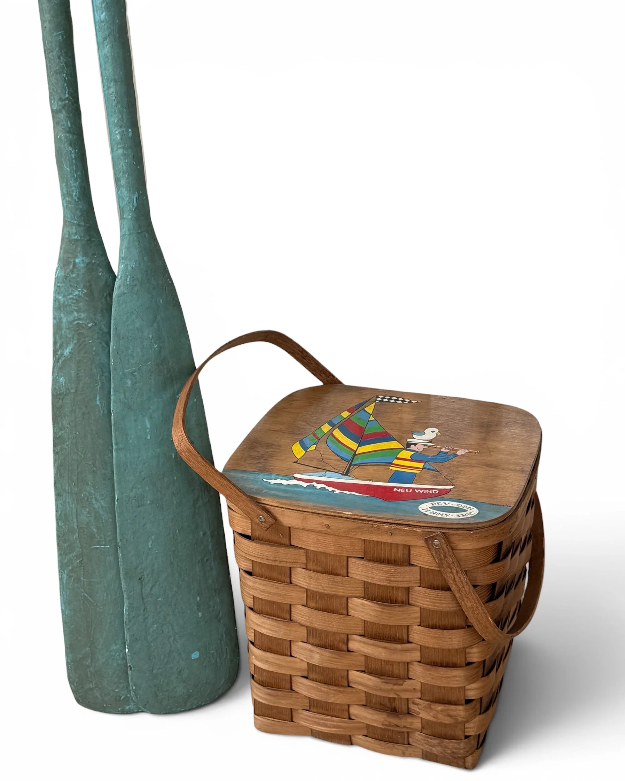 vintage picnic basket styled with a pair of vintage turquoise wooden boat oars