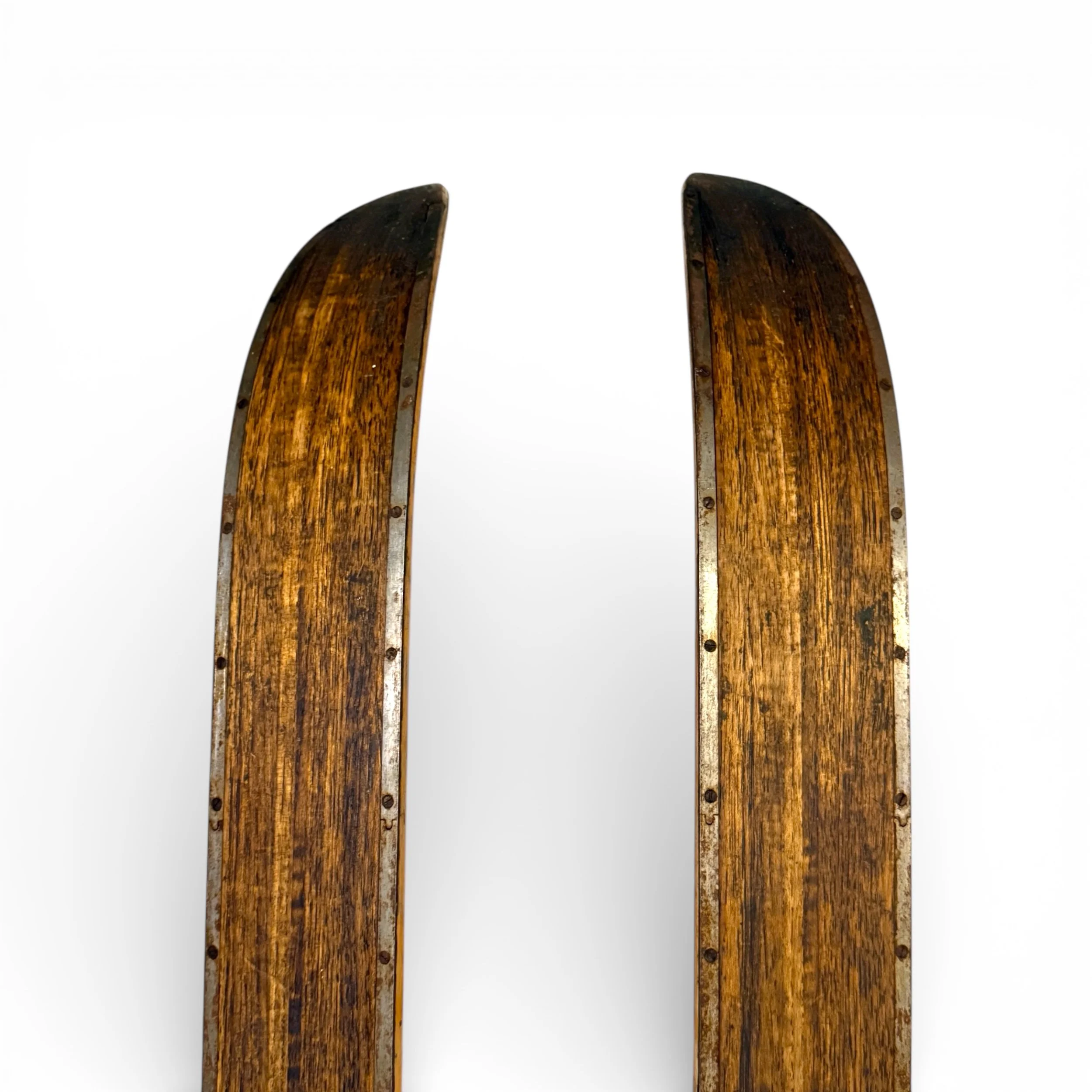close up view of back of vintage snow skis with ski poles detailing wood grain