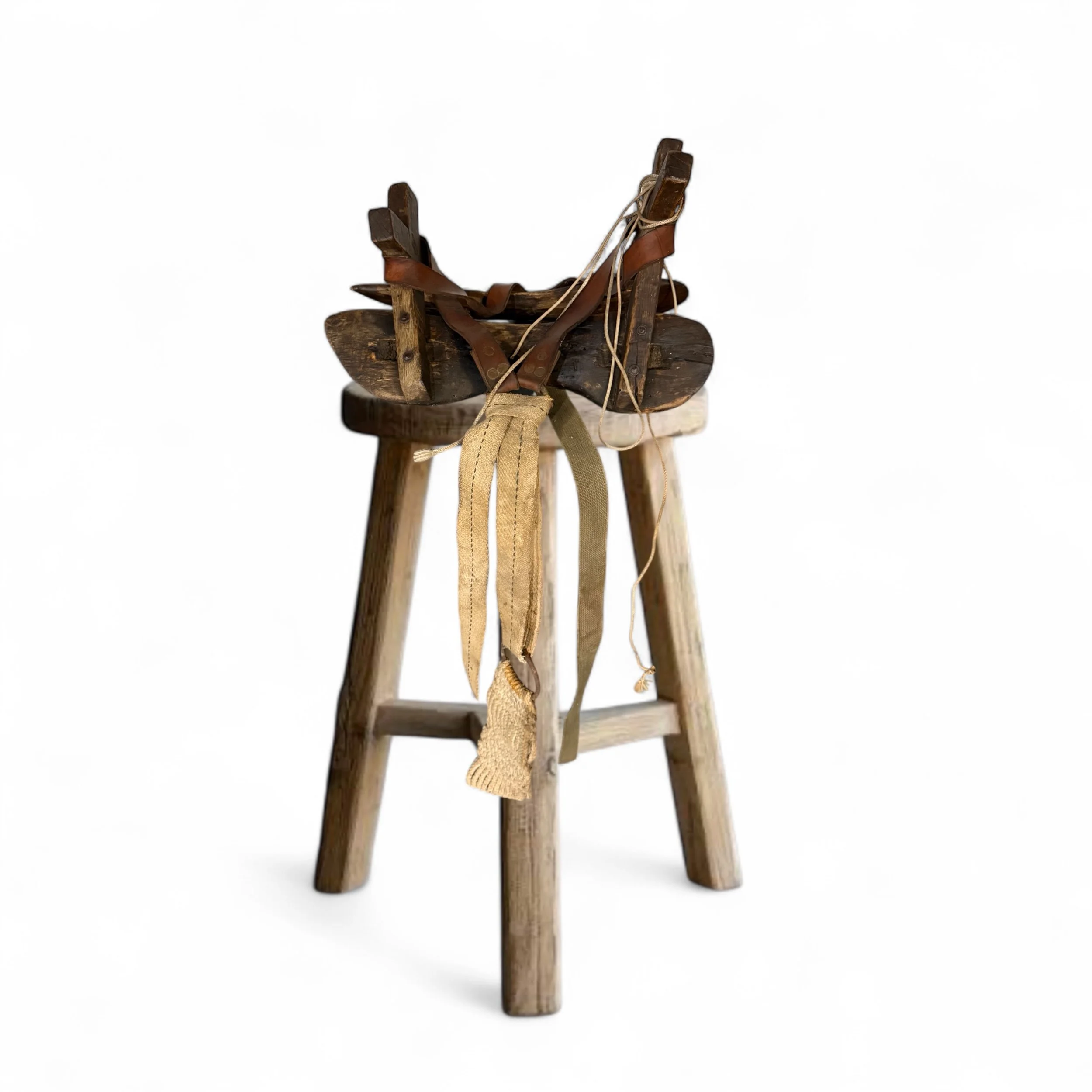 Vintage mule pack saddle with rope and leather details styled on a rustic wooden bar stool.