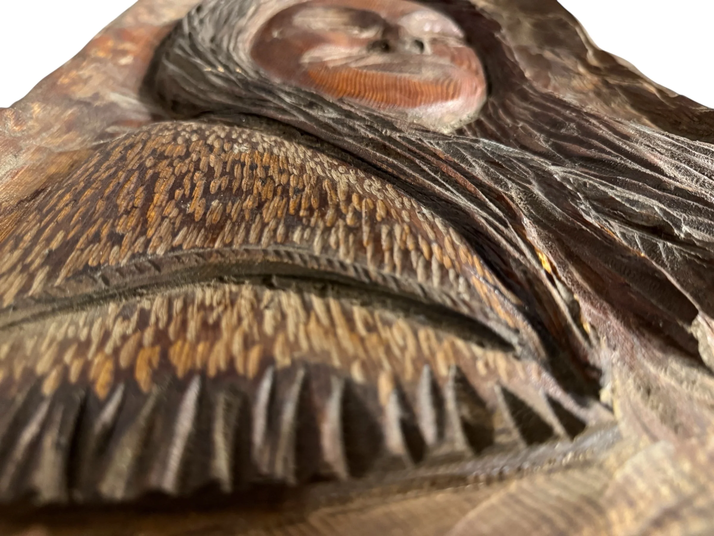 Detailed close-up of vintage wood carving showing carved hair texture and facial features