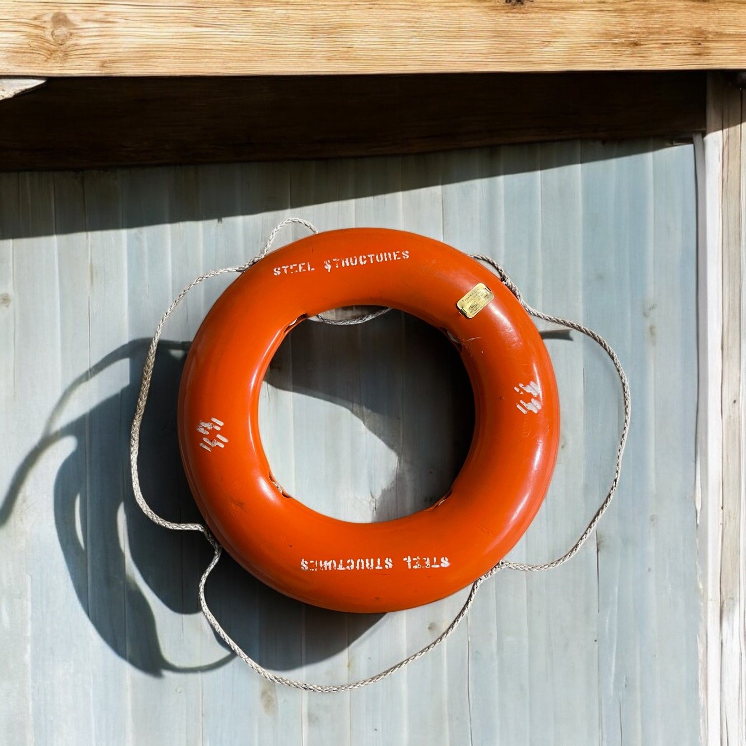 Vintage life preserver buoy, BF Goodrich, manufactured by Tapatco, Inc., 1970s with gold plate, orange with rope.
