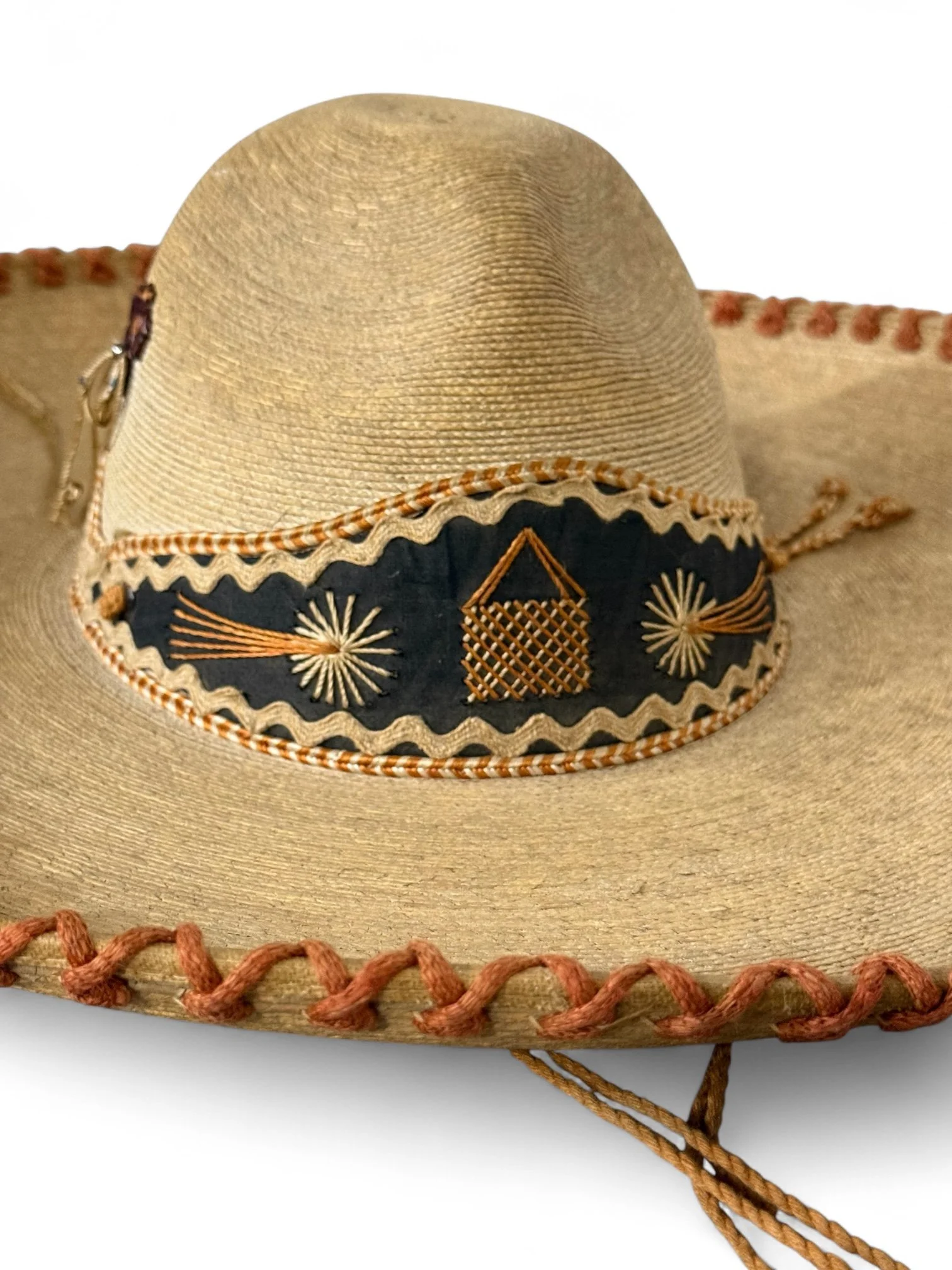 Close up of a vintage youth sized Mexican sombrero made of palm leaf with embroidered and leather details, ideal for kids' costume or decorative wall display.