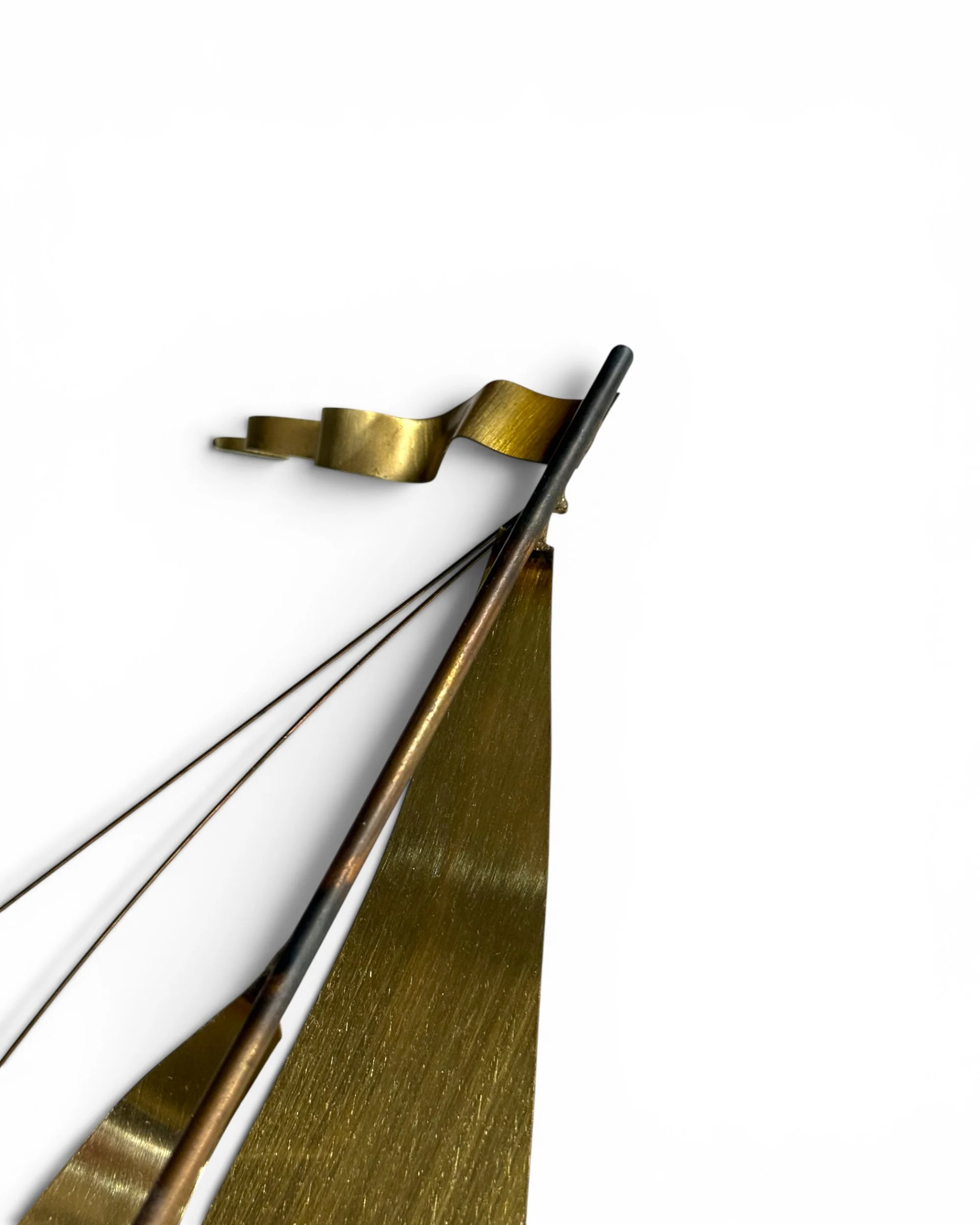 Close up of polished brass sails on vintage DeMott sailboat sculpture.