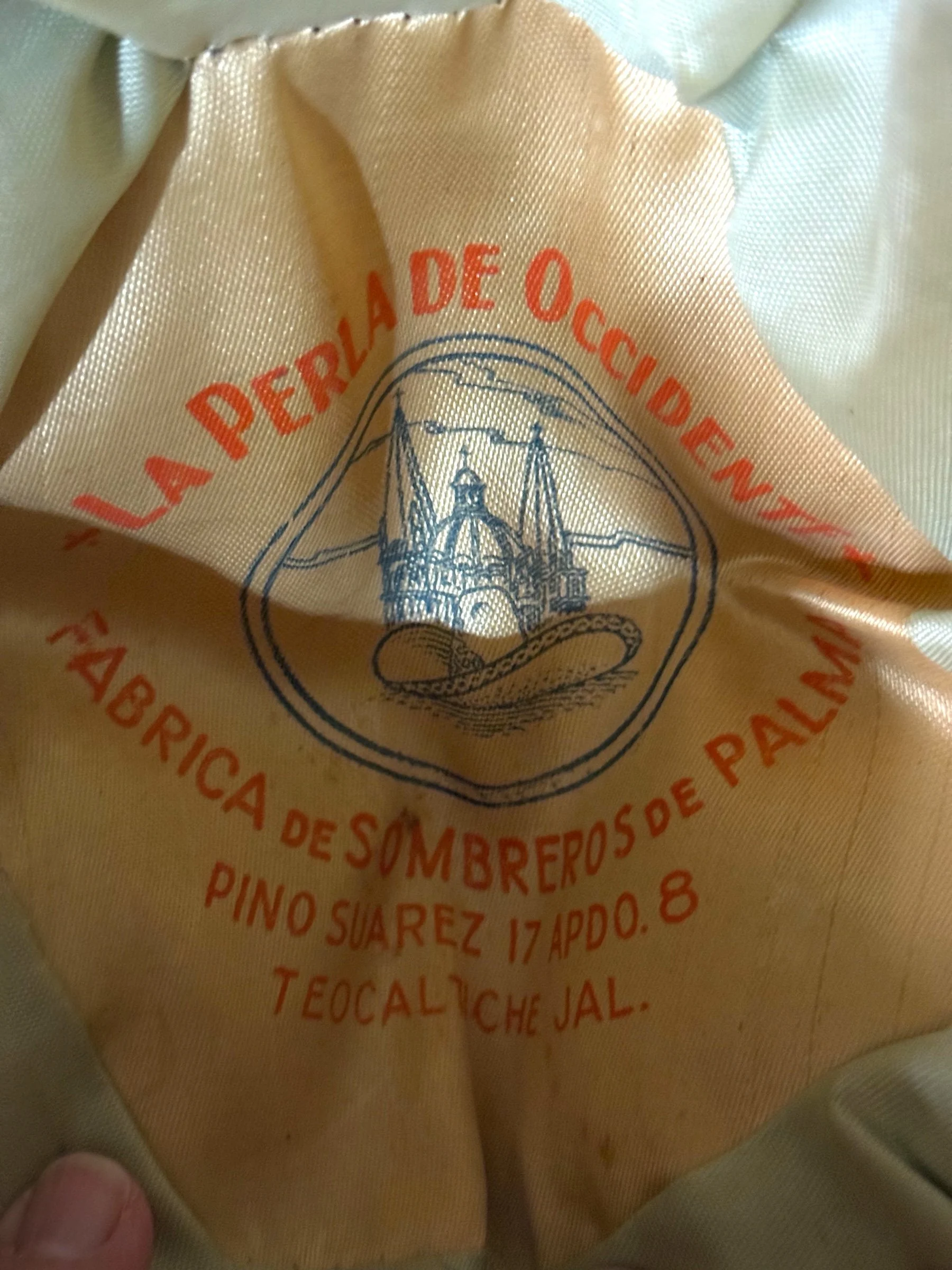 Close-up of printed satin liner reading La Perla de Occidente Fábrica de Sombreros de Palma Teocaltiche Jalisco.