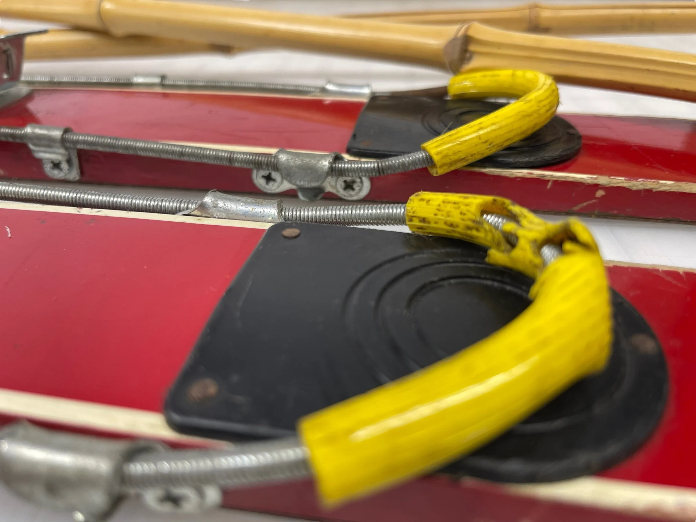 Close up view of metal bindings on a pair of vintage mid century kids Alpine snow skis.