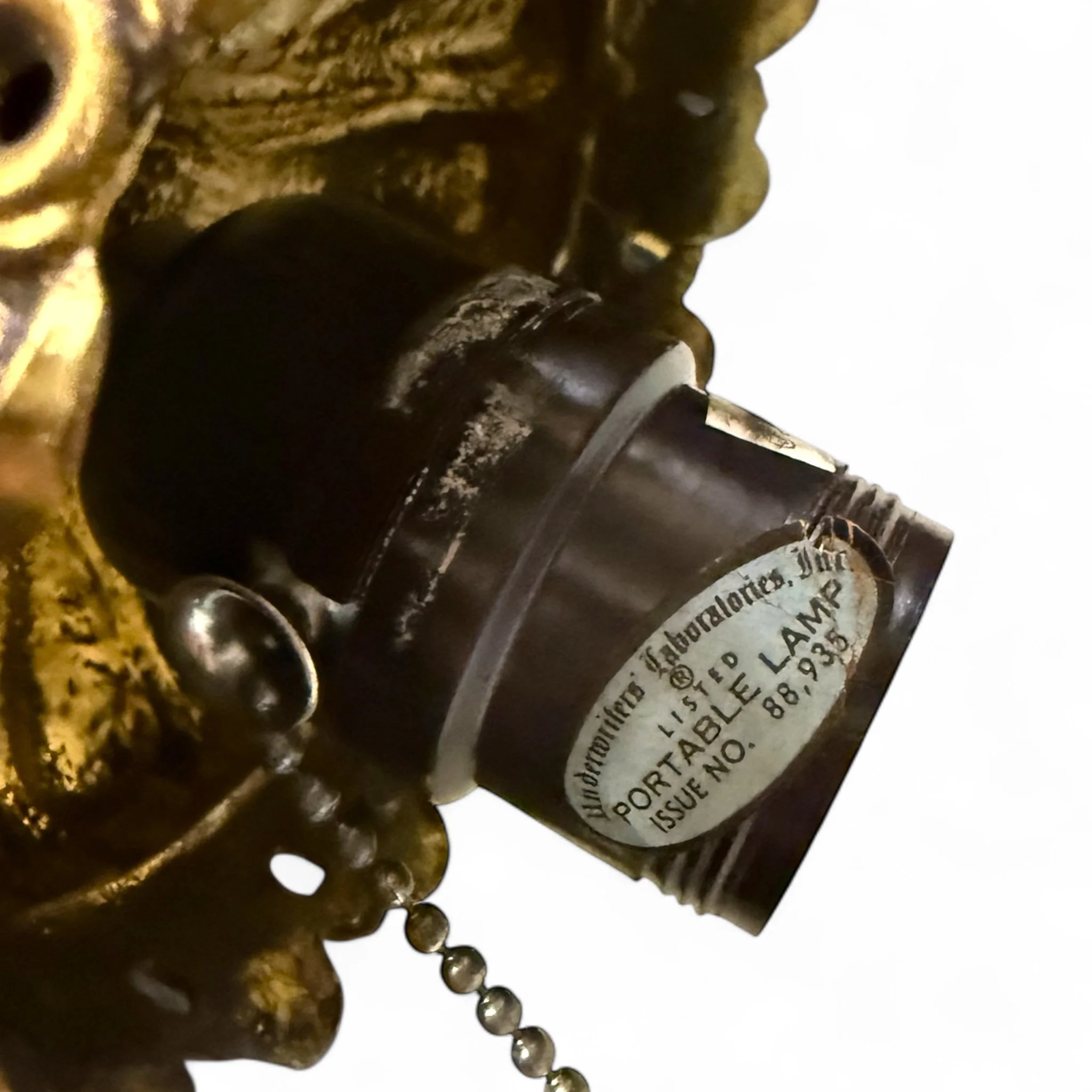 Close up view of a vintage bakelite socket on a 1960s swag hanging light with chain.