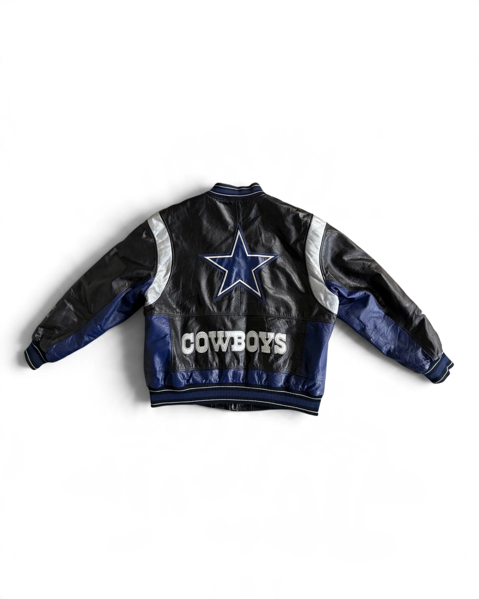 flat lay back view of vintage 1990s leather Dallas Cowboys jacket, G-III Apparel Group Carl Banks licensed with large star and COWBOYS embroidered