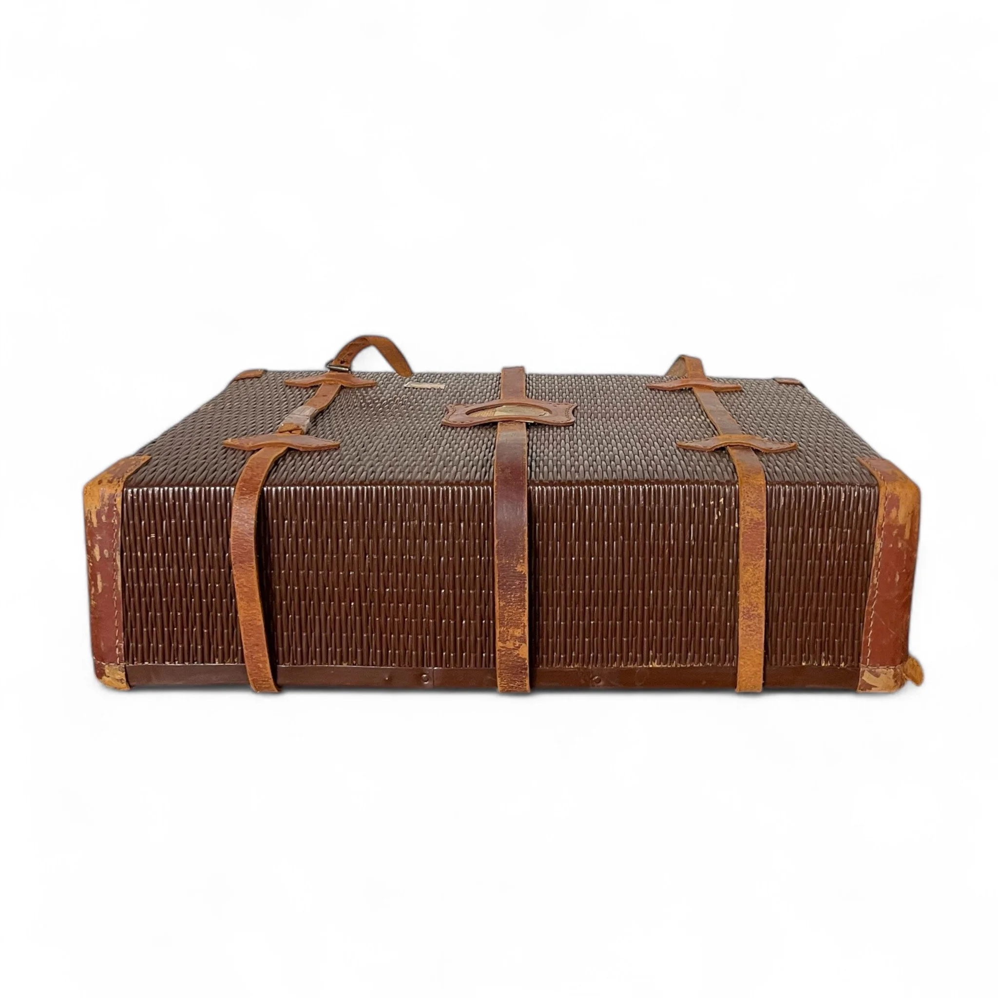 An antique rattan travel suitcase with leather corners and straps, flower pattern cloth interior, featuring parts of The Yamato and United States Customs Service travel stickers. Unique decor item.