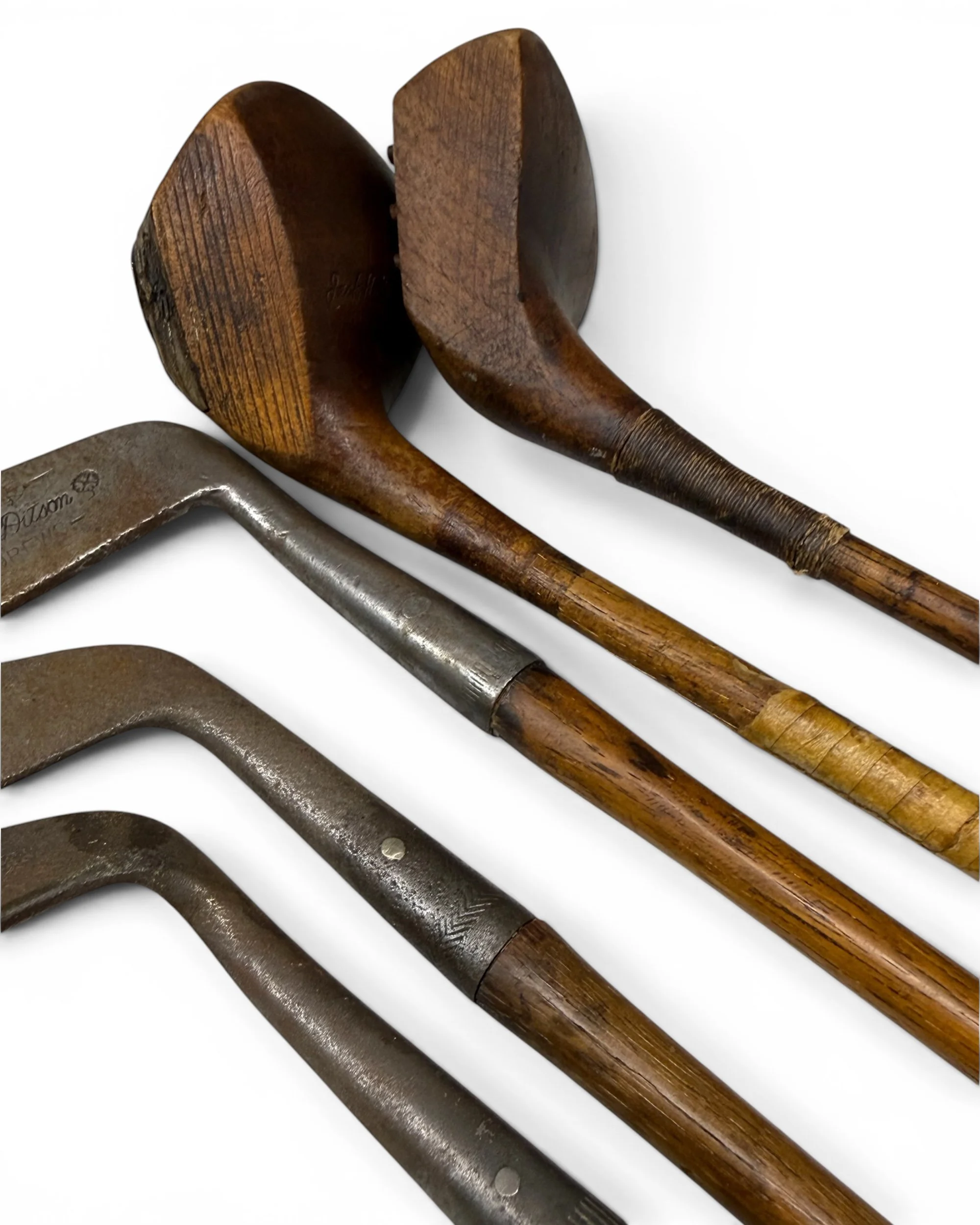 Antique golf clubs featuring wood shafts, early iron heads and classic golf craftsmanship.