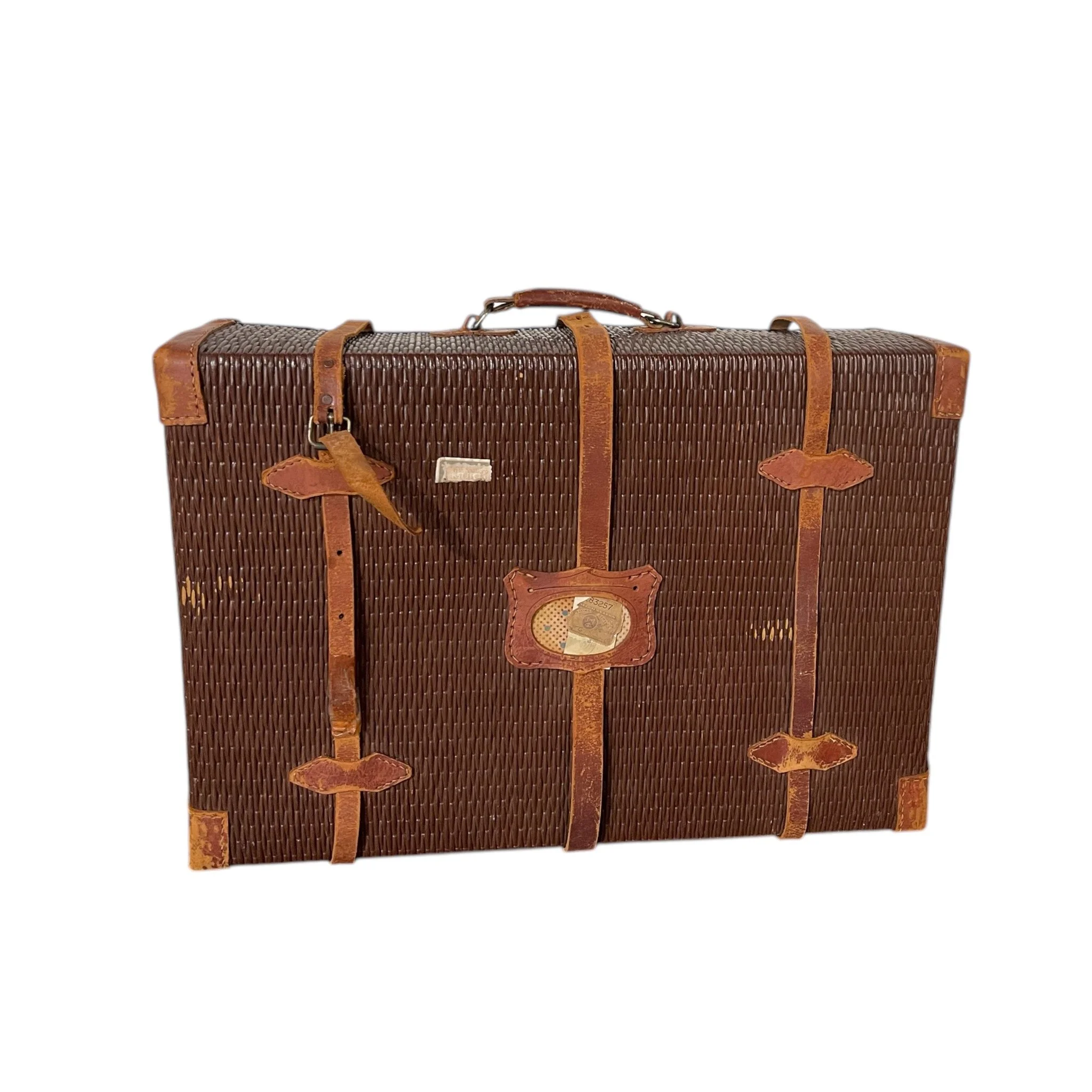 An antique rattan travel suitcase with leather corners and straps, flower pattern cloth interior, featuring parts of The Yamato and United States Customs Service travel stickers. Unique decor item.