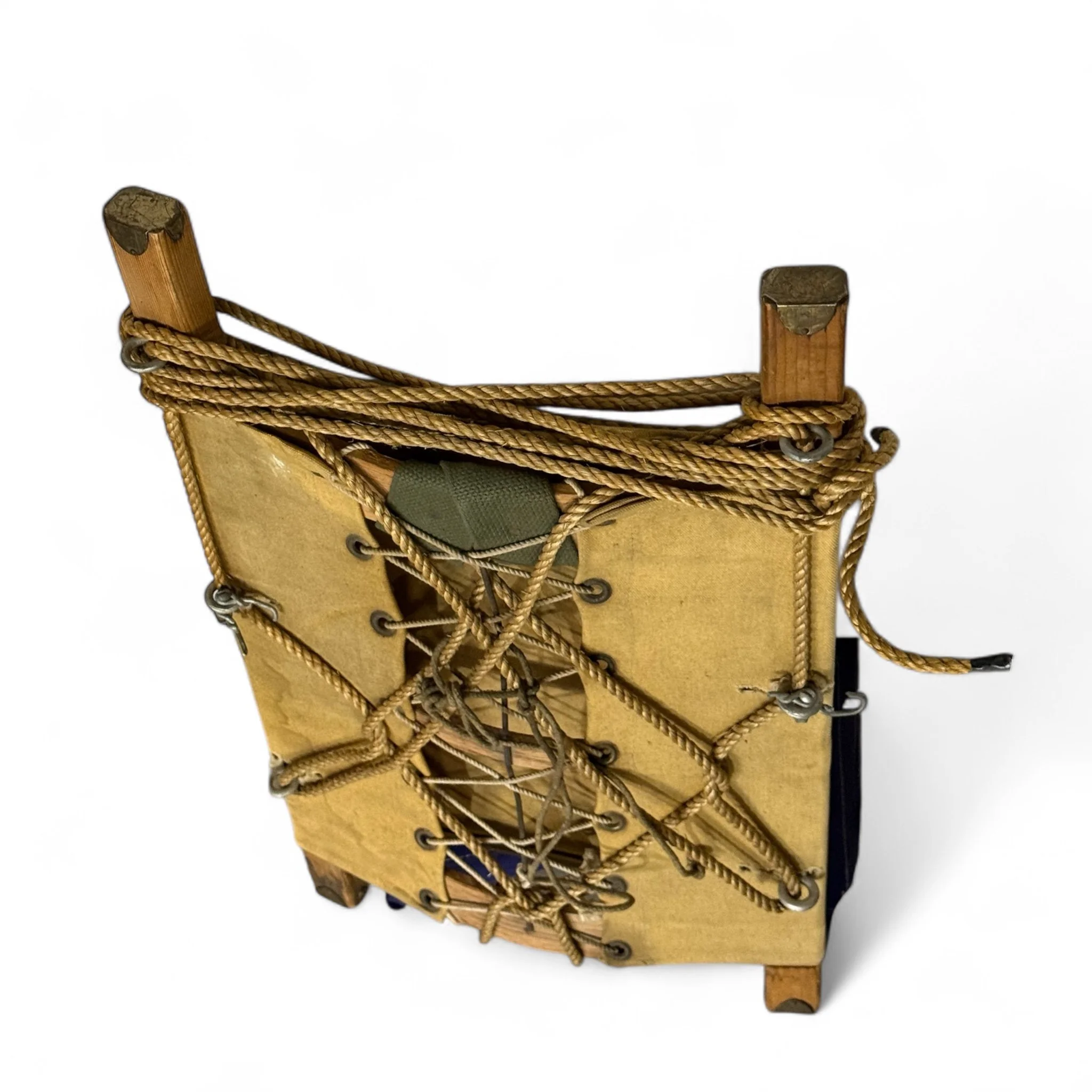 Vintage wooden packboard with rope accent used as rustic wall decor for hunting lodge or cabin display.