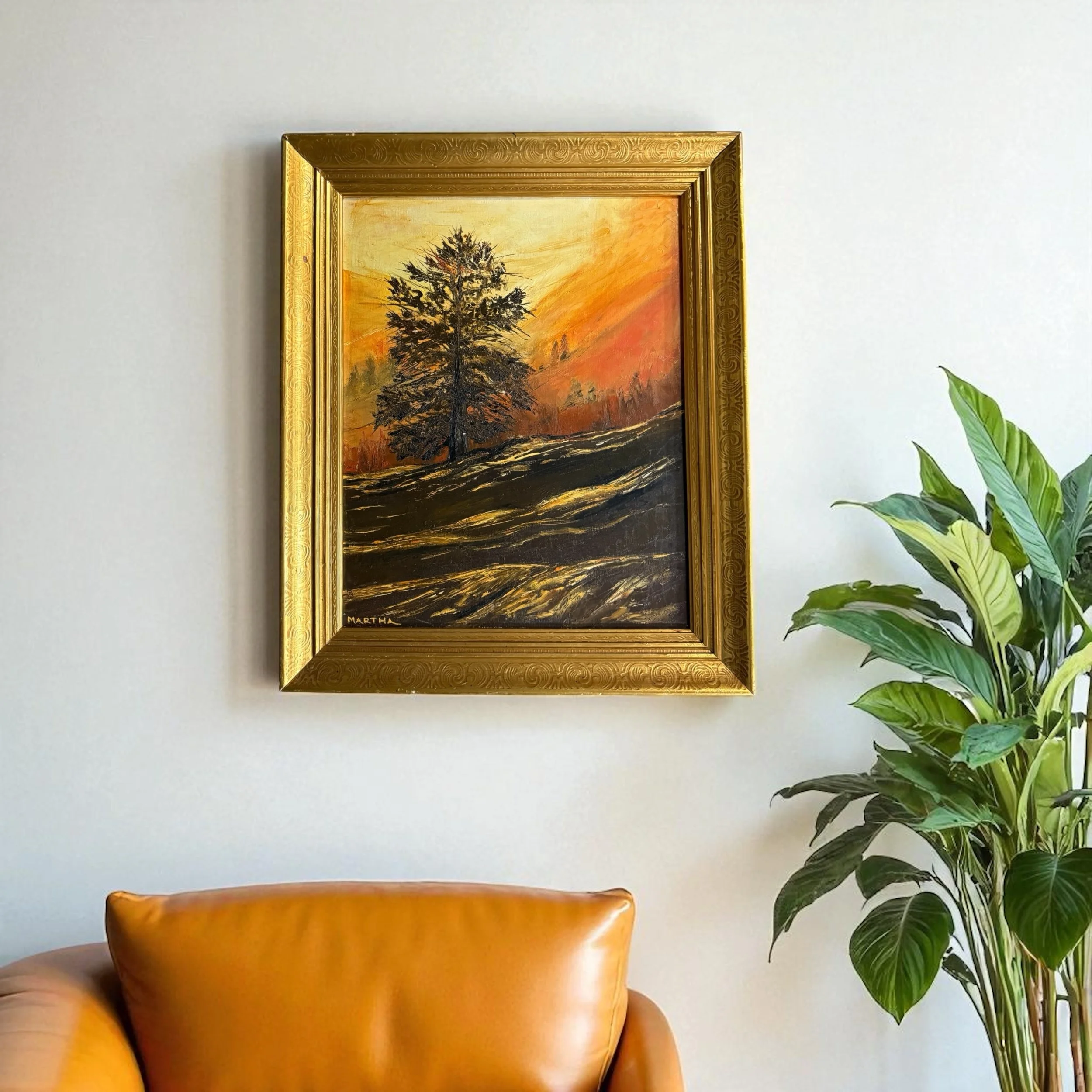 Framed golden sunset painting with ornate gold frame in a modern living room