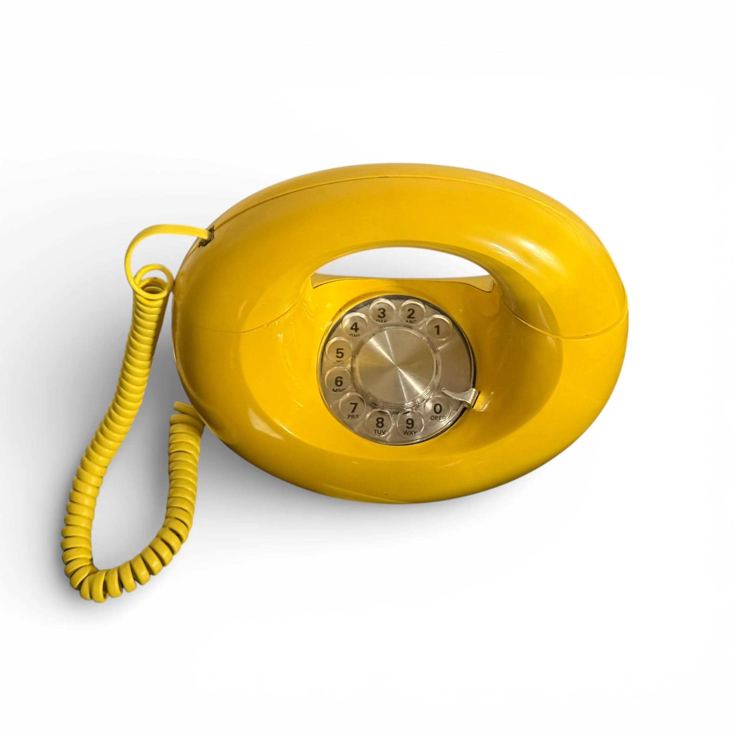 Top view of rotary dial on a vintage yellow donut phone by Western Electric