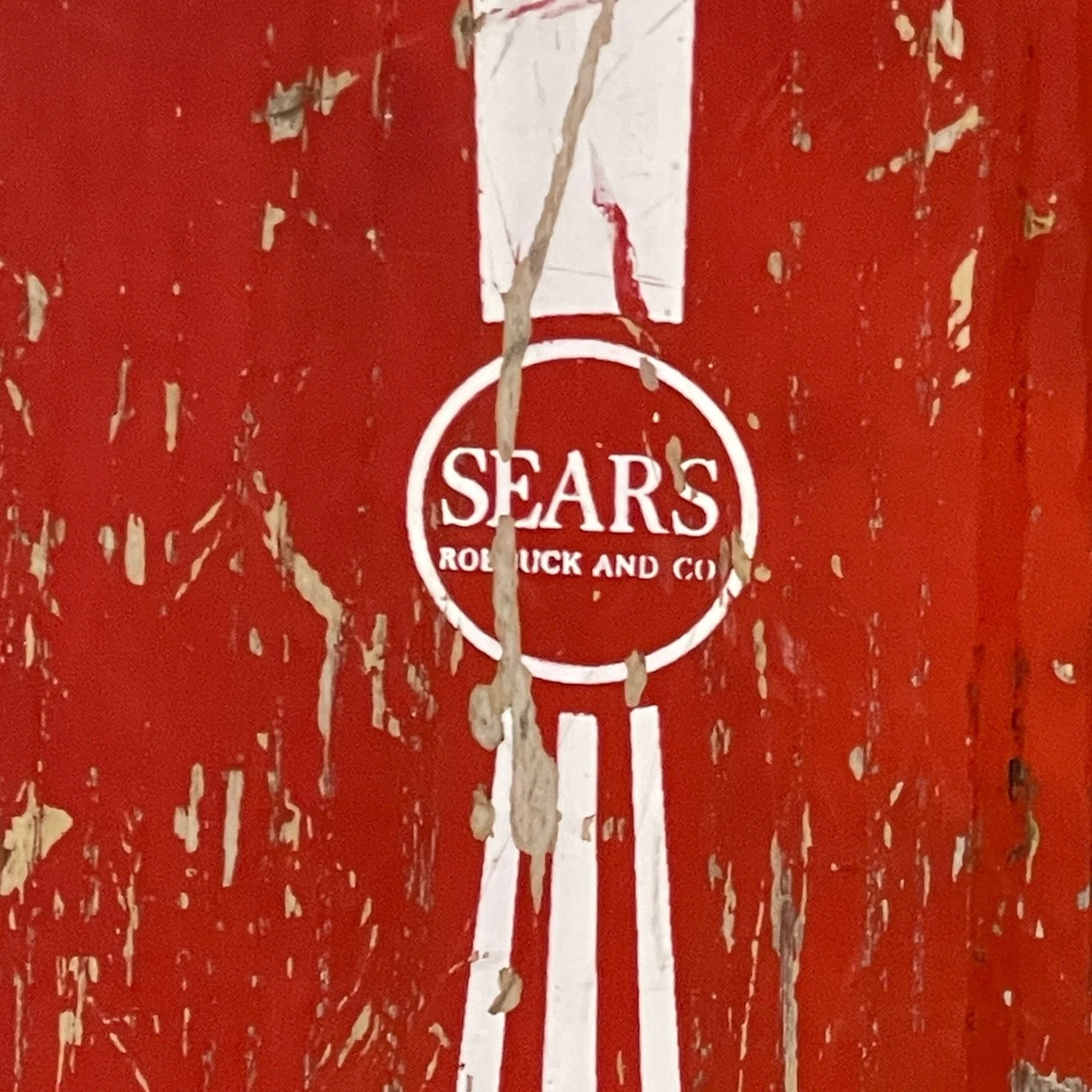 Vintage pair of red white Sears Shorty Combo wooden water skis, well weathered and perfect for beach house decor.