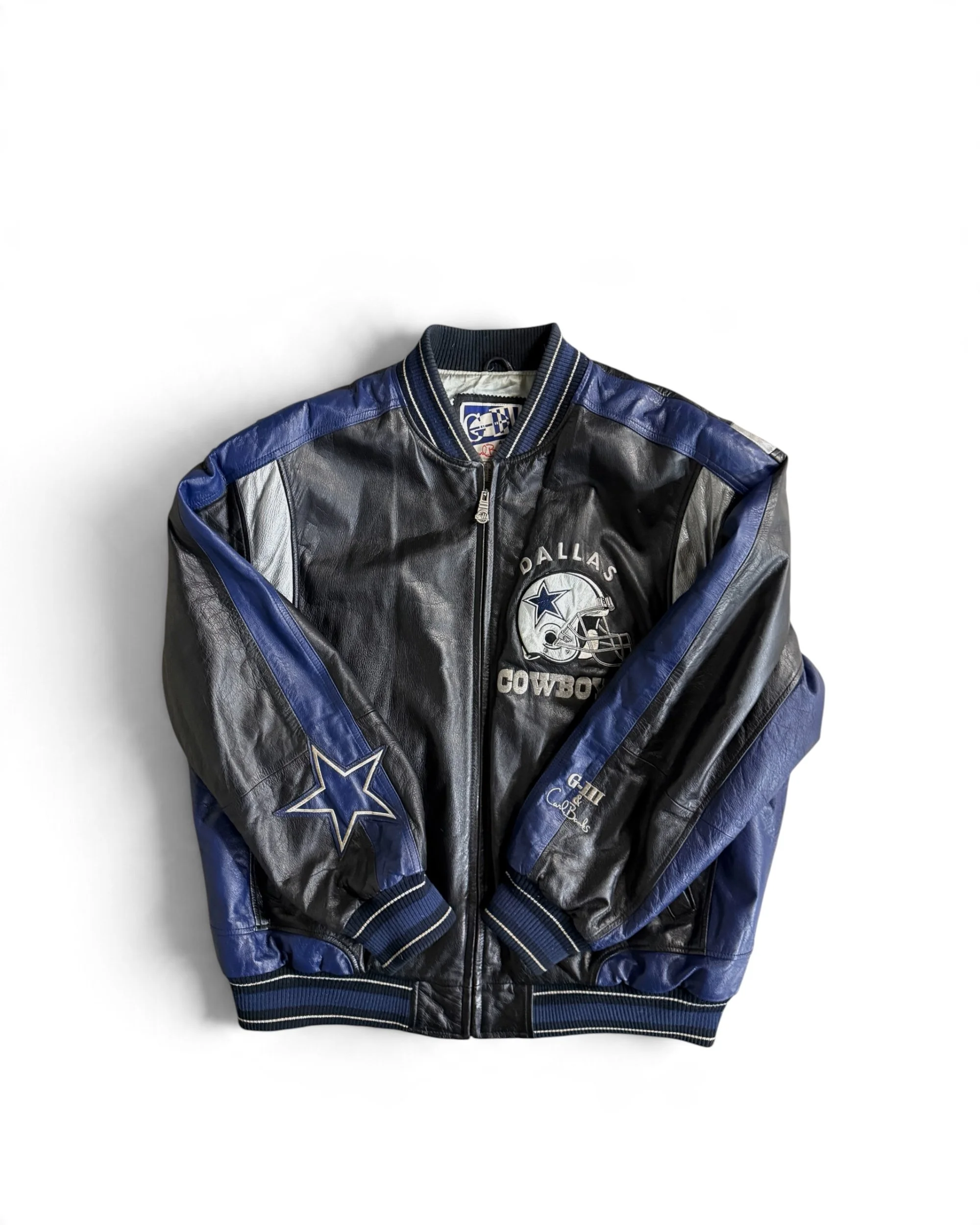 A black & blue leather bomber jacket featuring the Dallas Cowboys logo and helmet graphic on the chest, a star emblem on the sleeve, zip front closure, ribbed knit cuffs & hem, blue & white stripes.