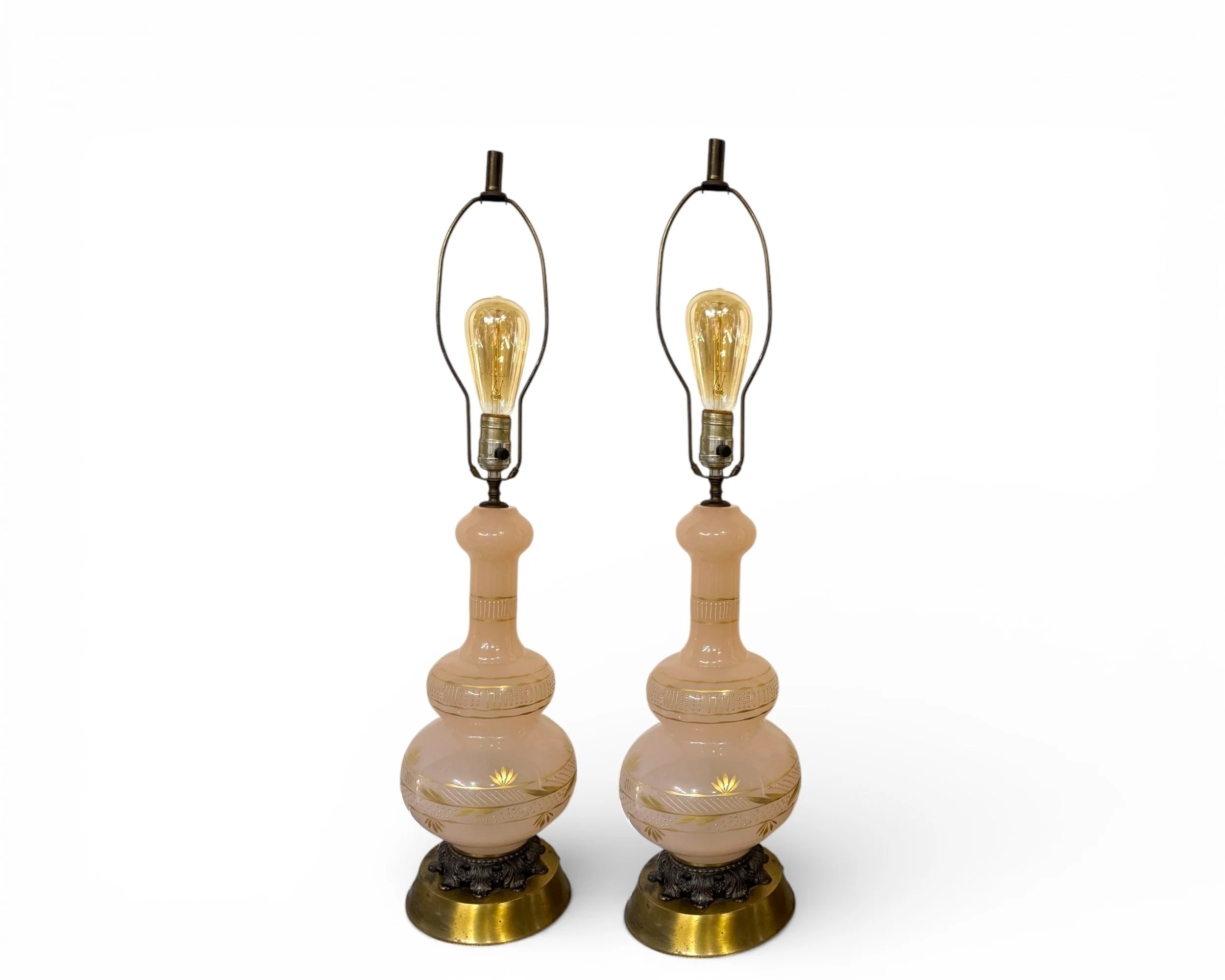 Decorative pink glass genie bottle lamps styled as statement vintage decor on solid white background