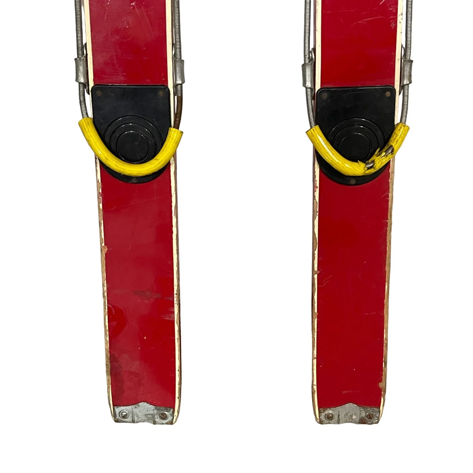 Close up view of kids red vintage snow skis with metal bindings.