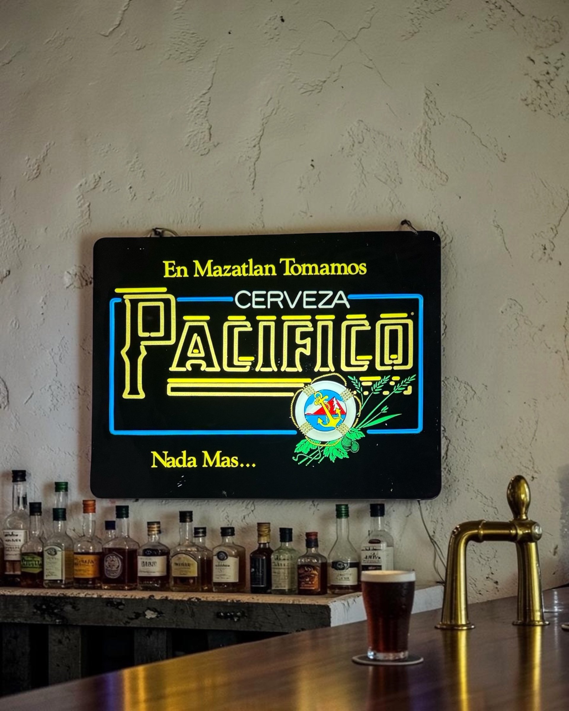 vintage Pacifico Cerveza lighted beer sign hanging above a bar