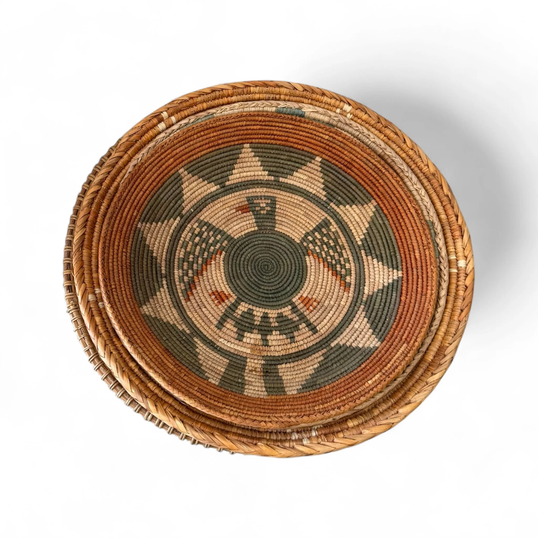 Set of 4 woven coil baskets with Southwestern geometric patterns and thunderbird design, displayed stacked together.