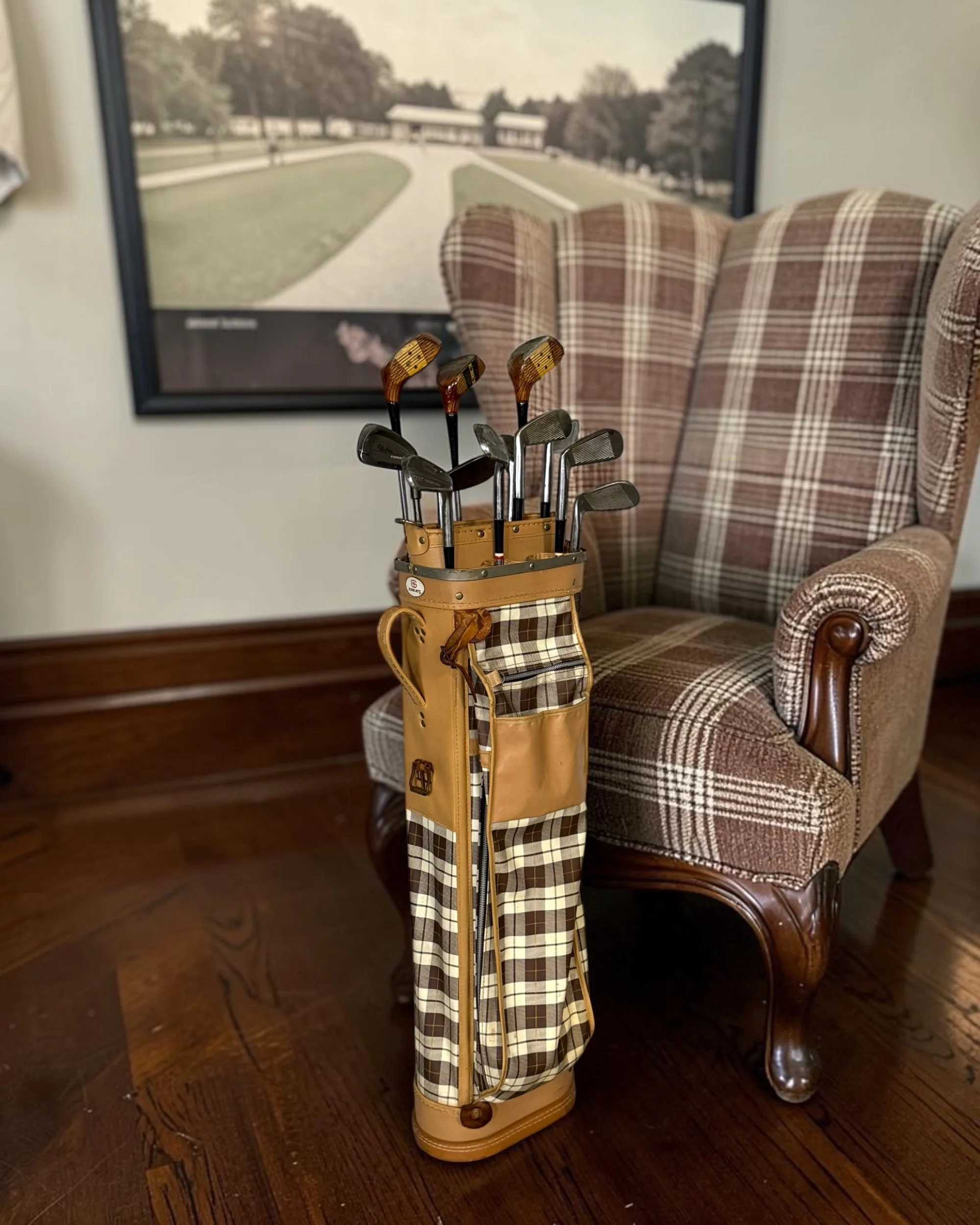 Golf-themed decor display featuring vintage golf clubs and Score-Rite plaid carry bag.