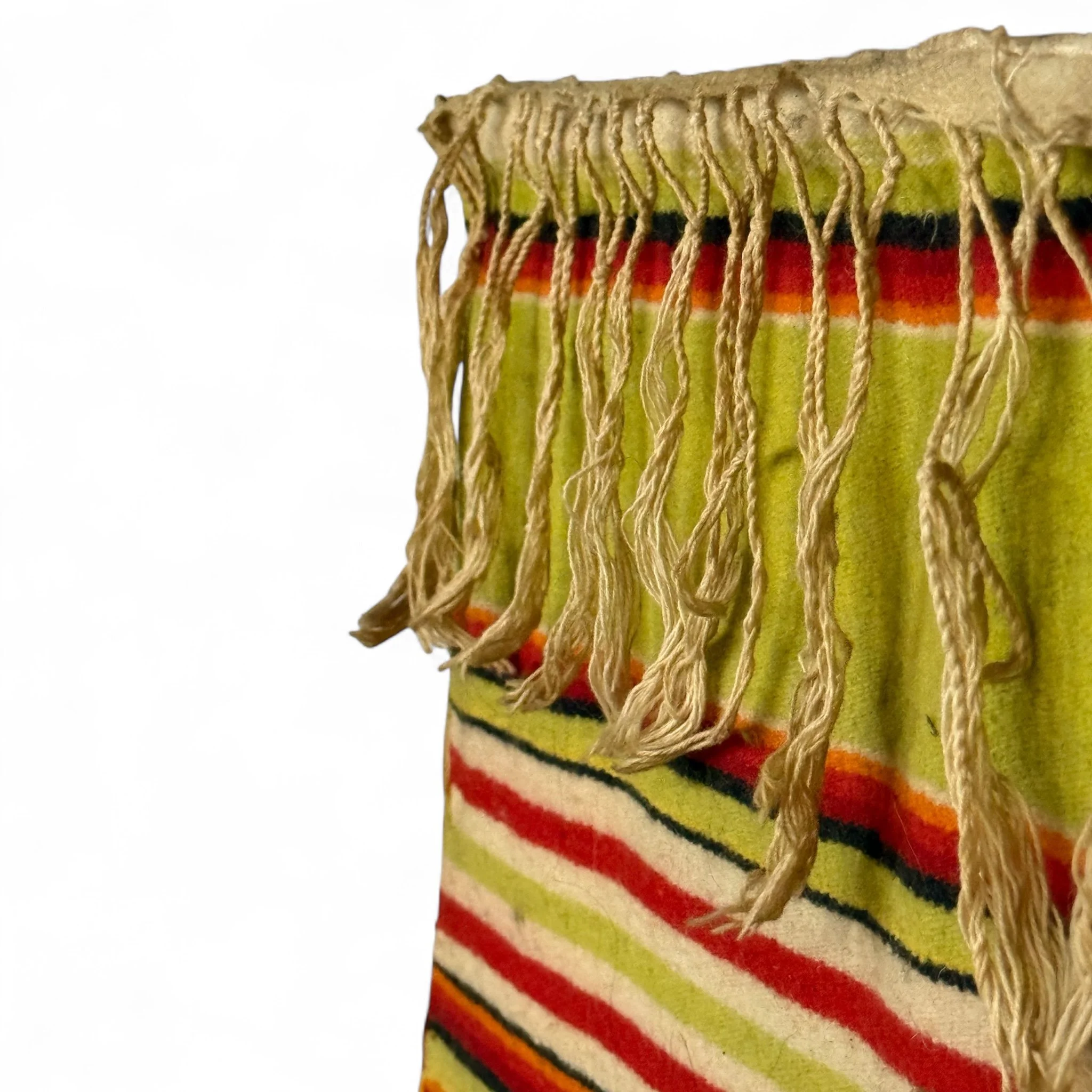 Handwoven vintage Mexican textile with fringe used as wall hanging.