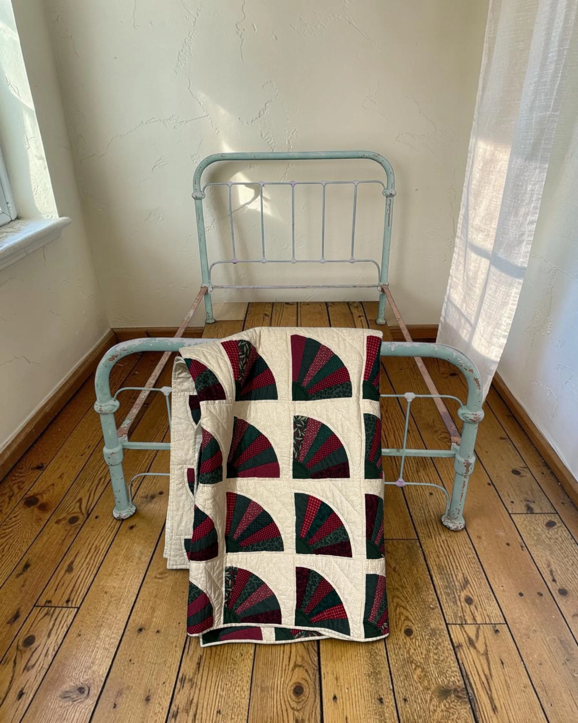 Traditional vintage patchwork quilt styled as a cozy throw blanket on a bed, highlighting the rich burgundy and forest green cottagecore aesthetic.