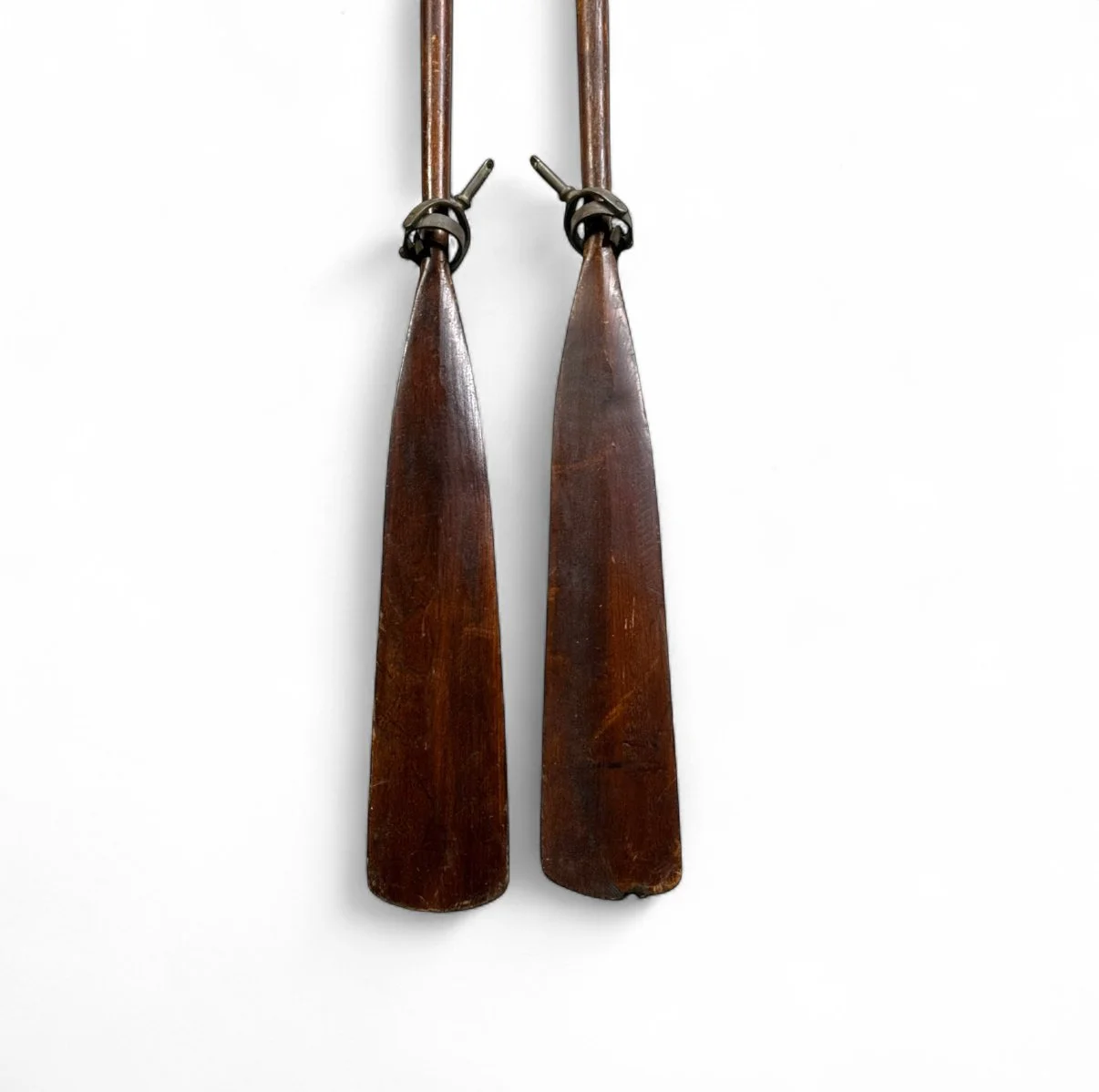 Pair of vintage wooden boat oars with dark brown stain and oar locks