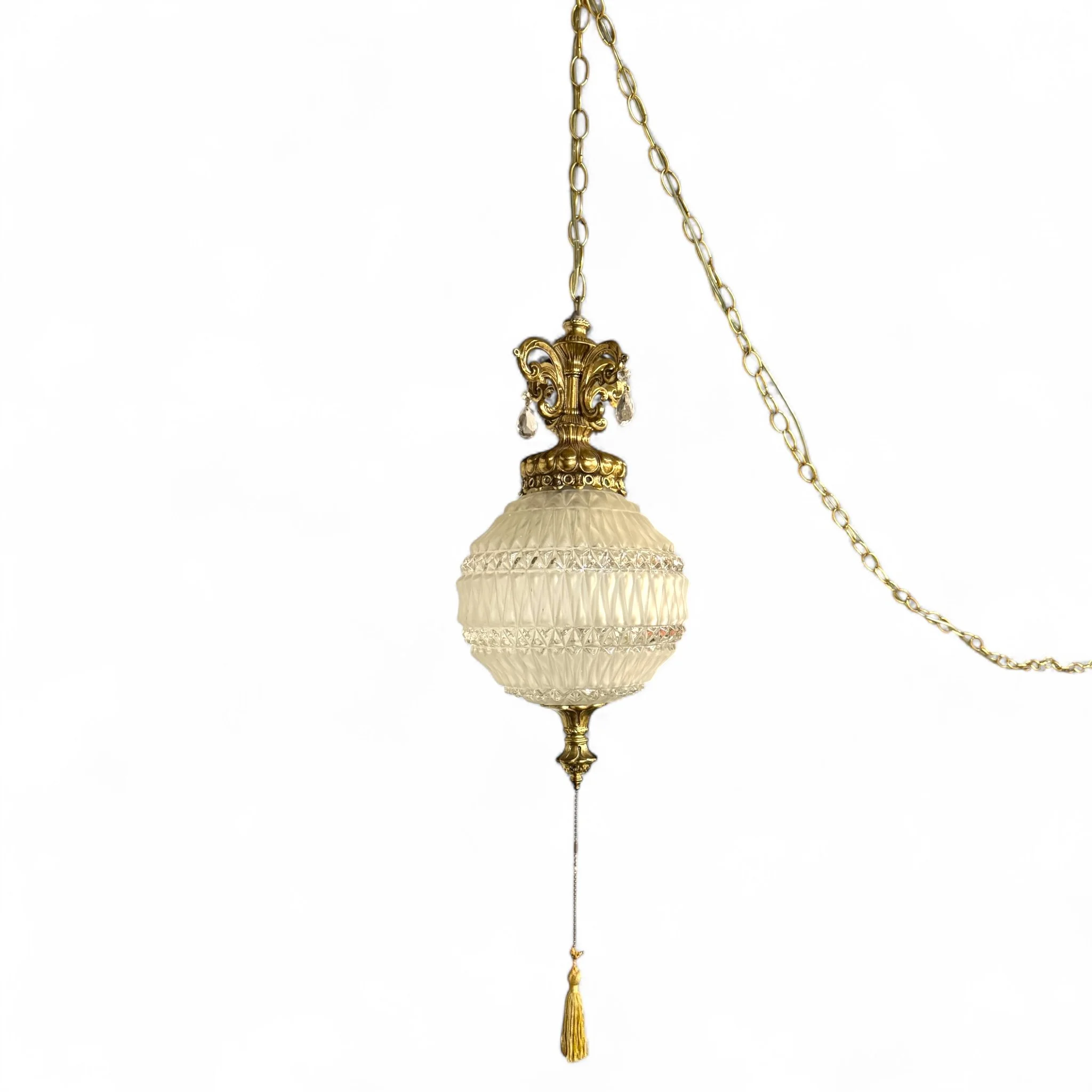 Vintage mid century plug in swag pendant light with ornate gold detailing and frosted beveled glass shade, hanging from a gold chain, perfect for glam interiors.