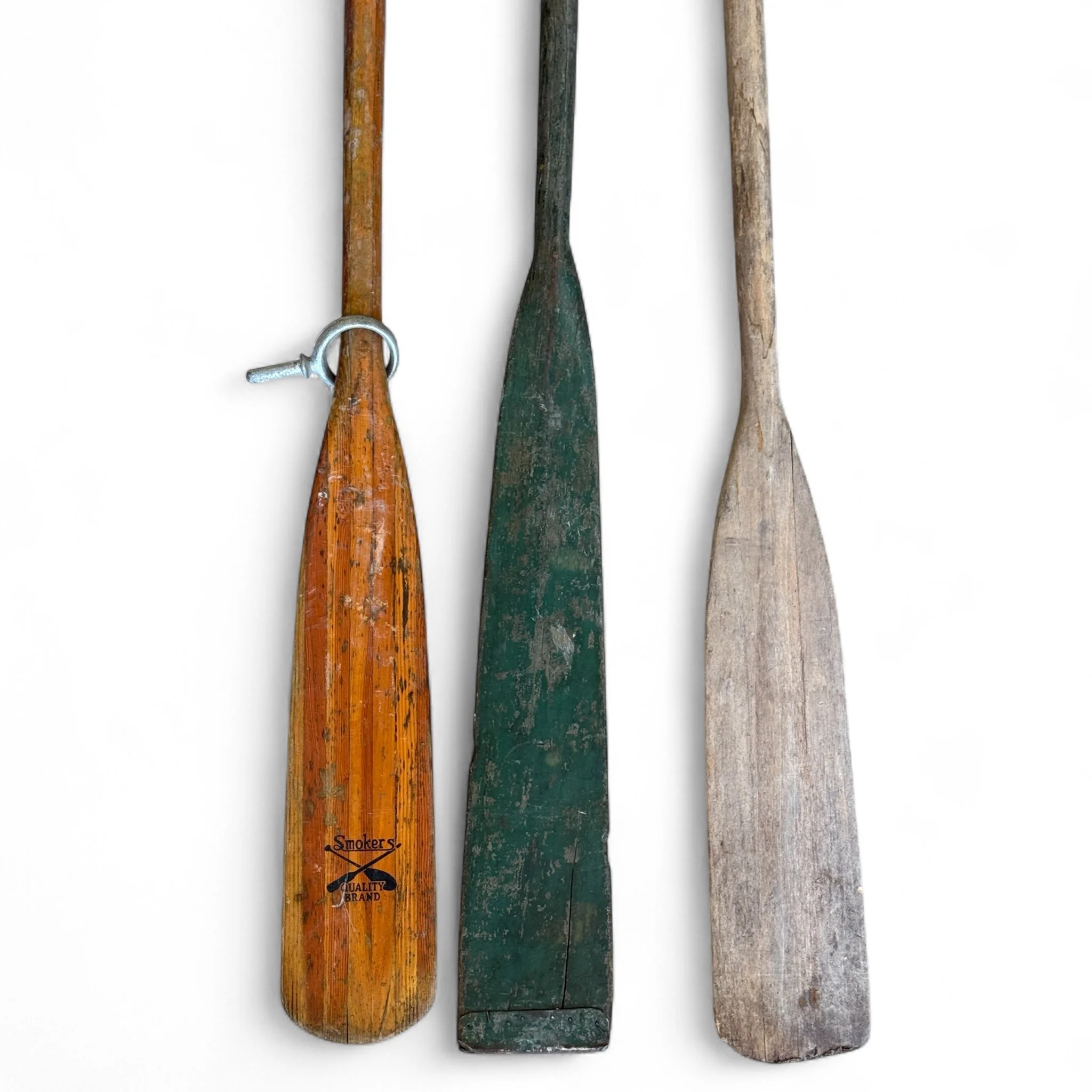 Set of 3 vintage wooden boat oars with leather grips and metal oar locks, ideal for nautical wall decor or rustic lake house styling.