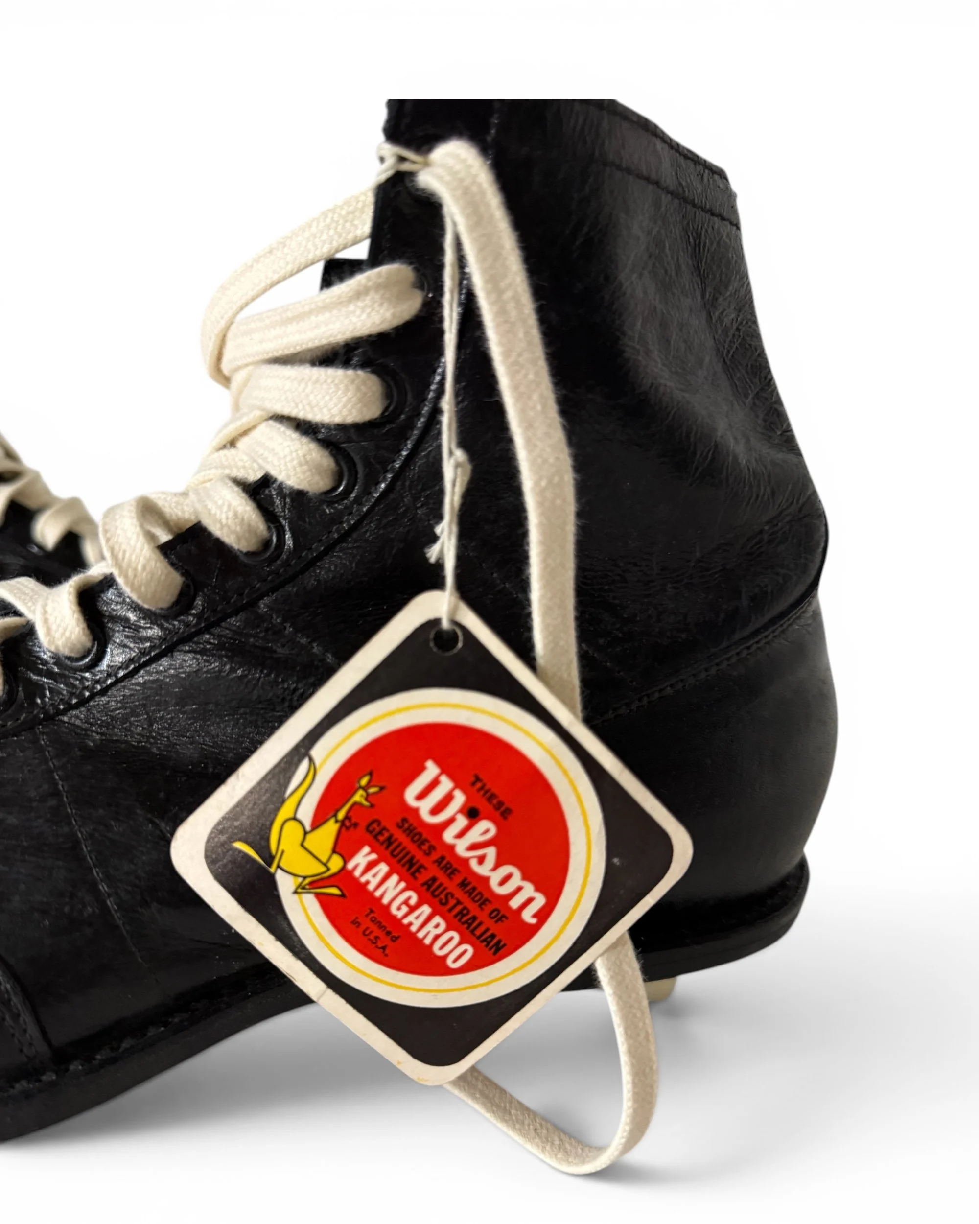 Close-up of original Wilson Kangaroo hang tag attached to unworn 1950s football cleats.