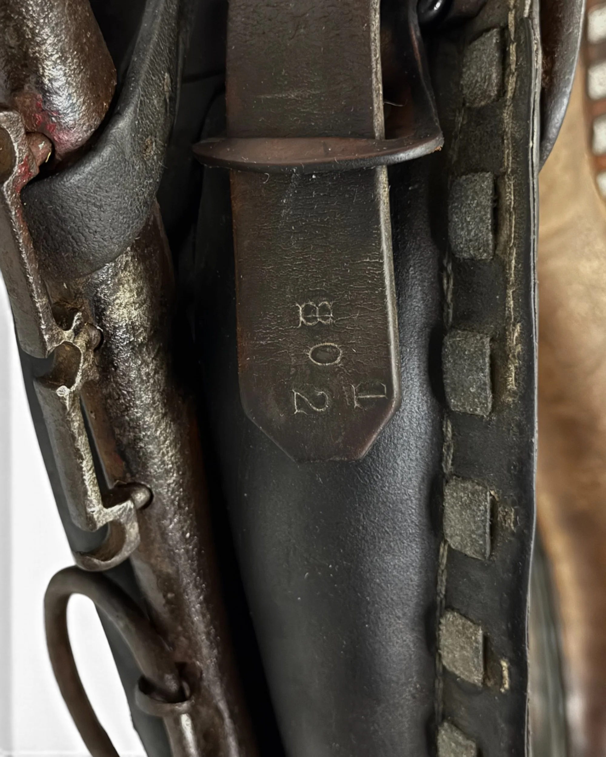 close up of aged brown leather on a vintage horse collar mirror showing natural wear & patina.
