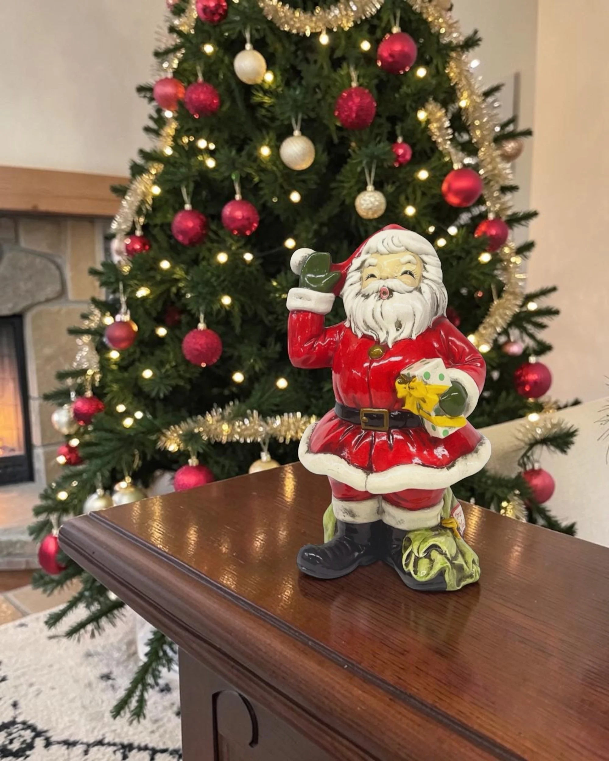 large vintage Josef Originals ceramic Santa Claus displayed in a living room with a decorated Christmas tree in the background