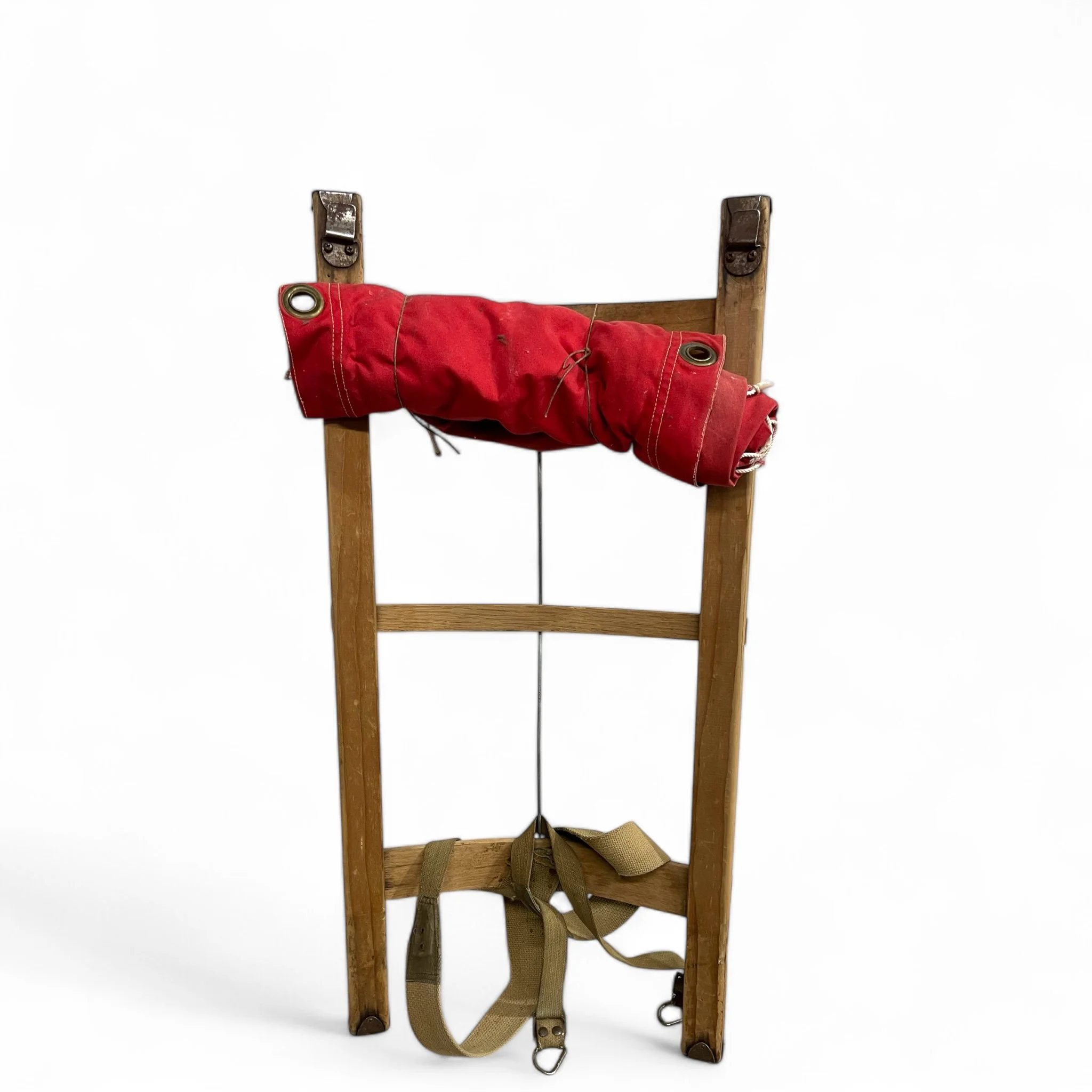 A vintage wooden packboard frame with red canvas backpack. Ideal cabin or lodge decor.