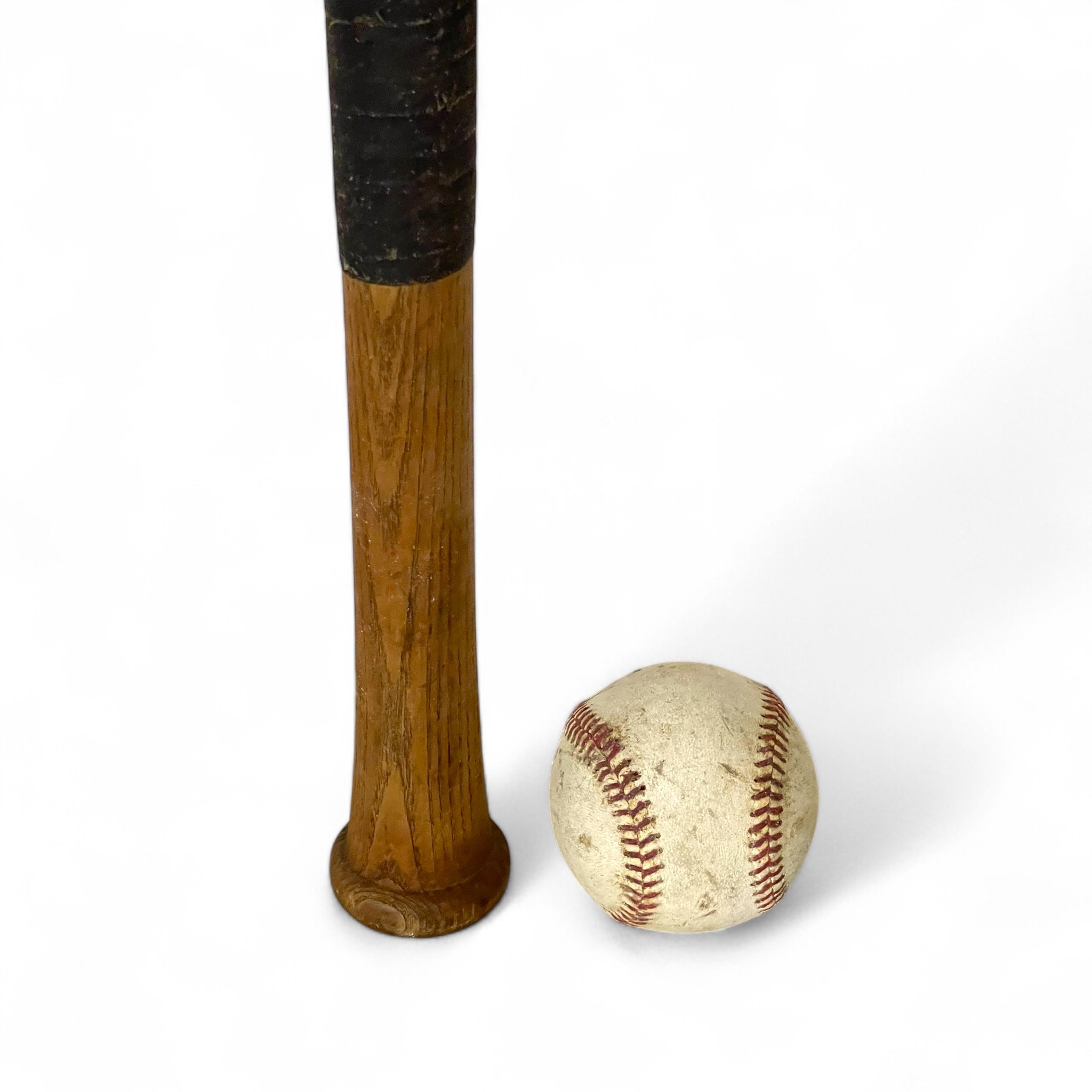 Close up of a vintage Wilson A1310 flamed fused wooden baseball bat, Nelson Fox Famous Players Special, paired with a classic vintage baseball, authentic sports memorabilia and collectibles.